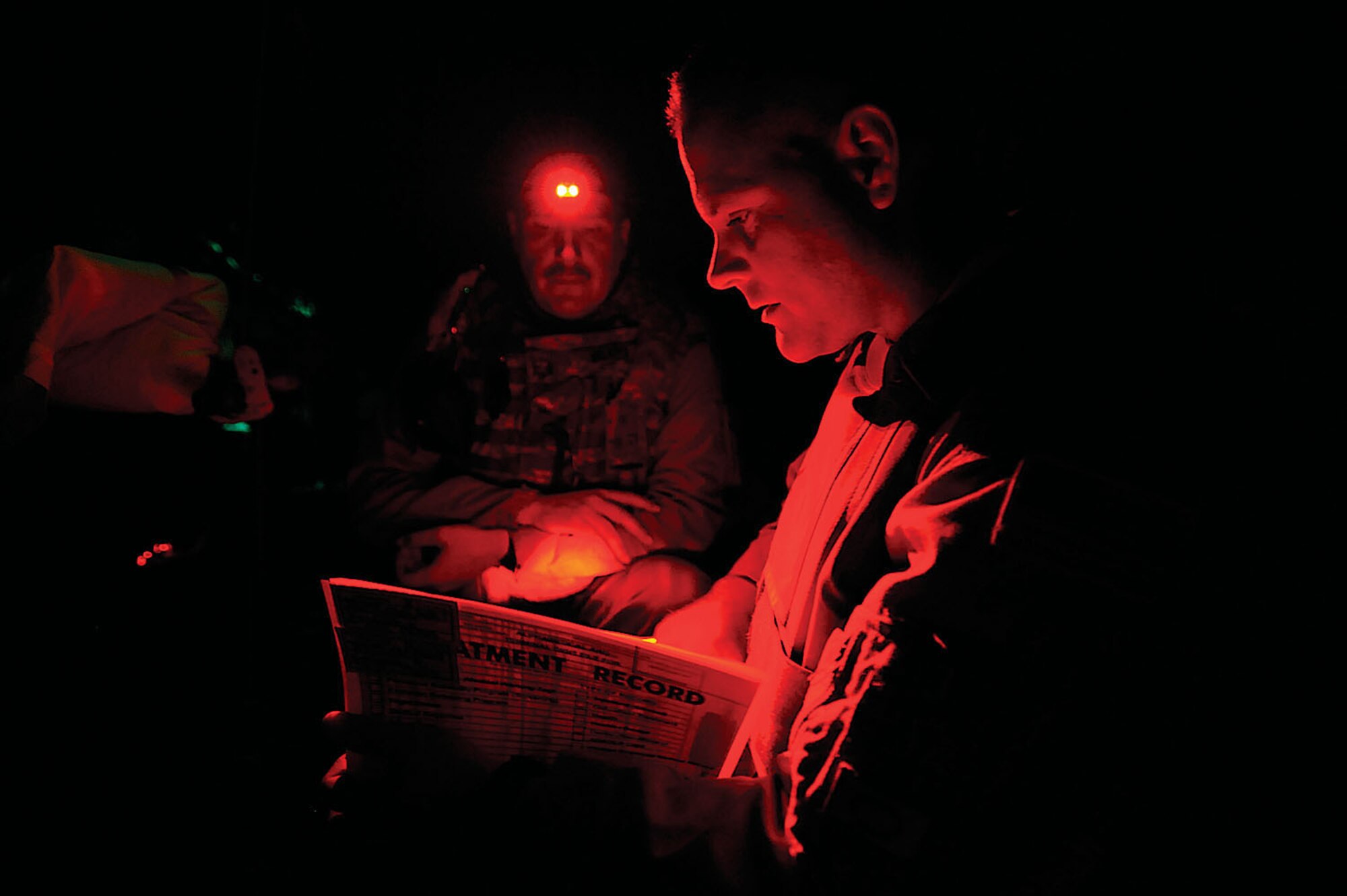 Capt. James Ryan, 446th Aeromedical Evaucation Squadron, checks patient records with light from Master Sgt. Scott Wilkes' head lamp during an aeromedical evacuation mission over Iraq Nov. 7. Captain Ryan, a flight nurse, was one of eight McChord Reservists deployed from October to December 2008 with the 332nd Expeditionary Aeromedical Evaucation Flight. Sergeant Wilkes, a charge medical technician with the 332nd EAEF, was deployed from McGuire AFB, N.J. (U.S. Air Force photo/Airman 1st Class Jason Epley)