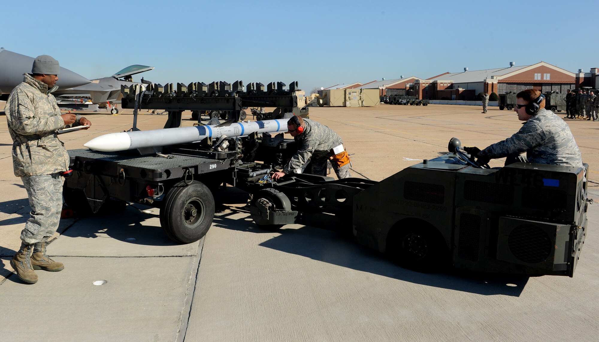 LANGLEY AIR FORCE BASE, Va. --  
 Staff Sgt. Joey Lavalley and Senior Airman Seamus Kane, 27th Aircraft Maintenance Unit weapons load crew members, prepare to load a missile while an inspector watches during the competition Jan. 23. Squadron finalists are annually judged on their accuracy, efficiency and speed. (U.S. Air Force photo/Airman Rebecca Montez)