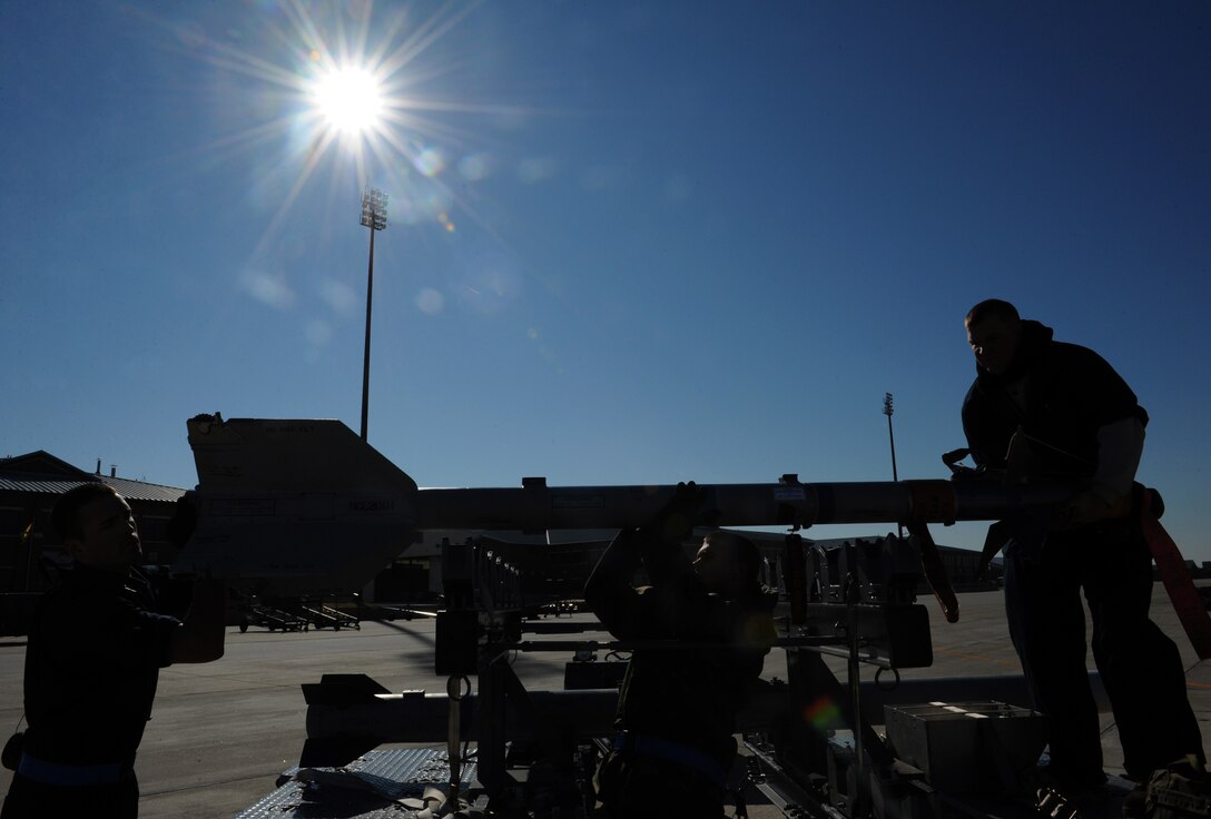LANGLEY AIR FORCE BASE, Va. -- Airmen 1st Class Joseph Garcia and Jared Joseph, and Staff Sgt. Ross Fontaine,94th Aircraft Maintenance Unit  weapons load crew members, prepare to load a missile onto an F-22 Jan. 23 during a weapons load crew competition. Squadron Finalists are judged on their accuracy, efficiancy and speed. (U.S. Air Force photo/Airman Rebecca Montez)