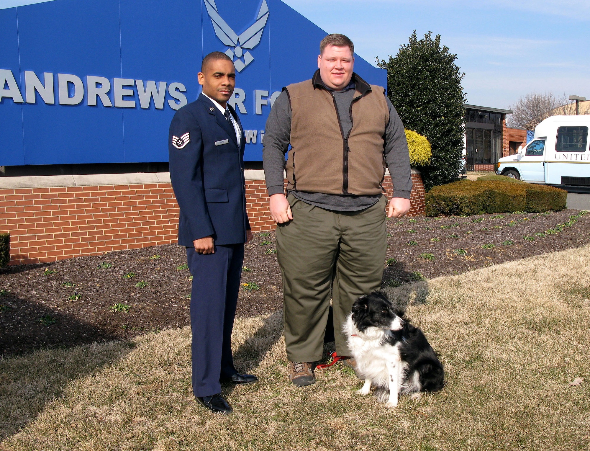 Staff Sgt. Paul White, airfield operations supervisor at Andrews Air Force Base, Md., left, and Dan Vredenburgh, a contractor who oversees the base's Bird/Wildlife Aircraft Strike Hazard program, rely on Bree, a two-tone border collie, as one of many tools to discourage birds and wildlife that could interfere with airfield operations. (Department of Defense photo/Donna Miles)