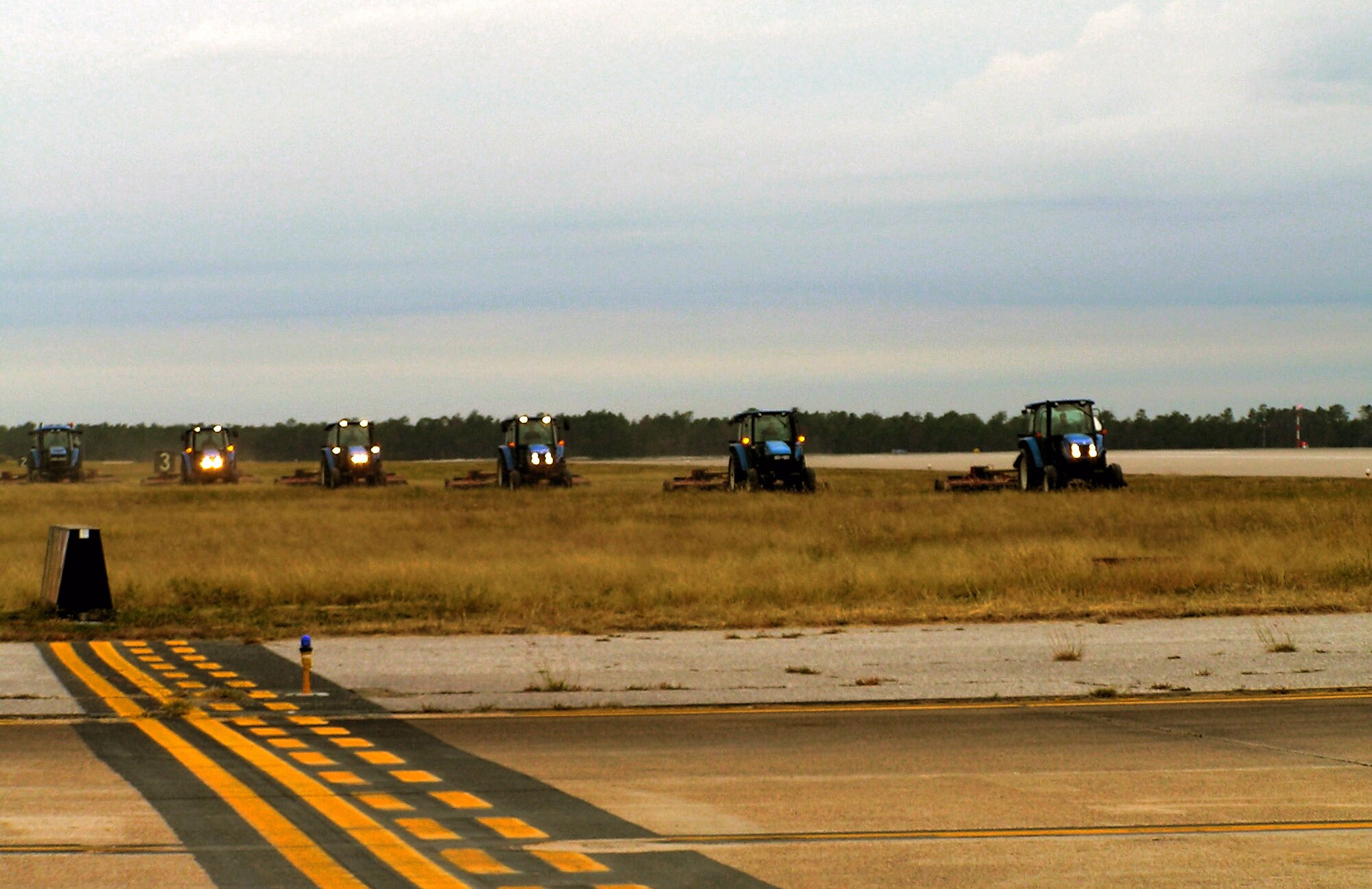 Officials credit monitoring grass height around runways with helping to deter birds that prevent a hazard to aircraft operations. Here, mowers at Eglin Air Force Base, Fla., ensure grass around the runway is more than 7 inches high, because birds are less likely to land somewhere if they can't see each other. (U.S. Air Force photo)