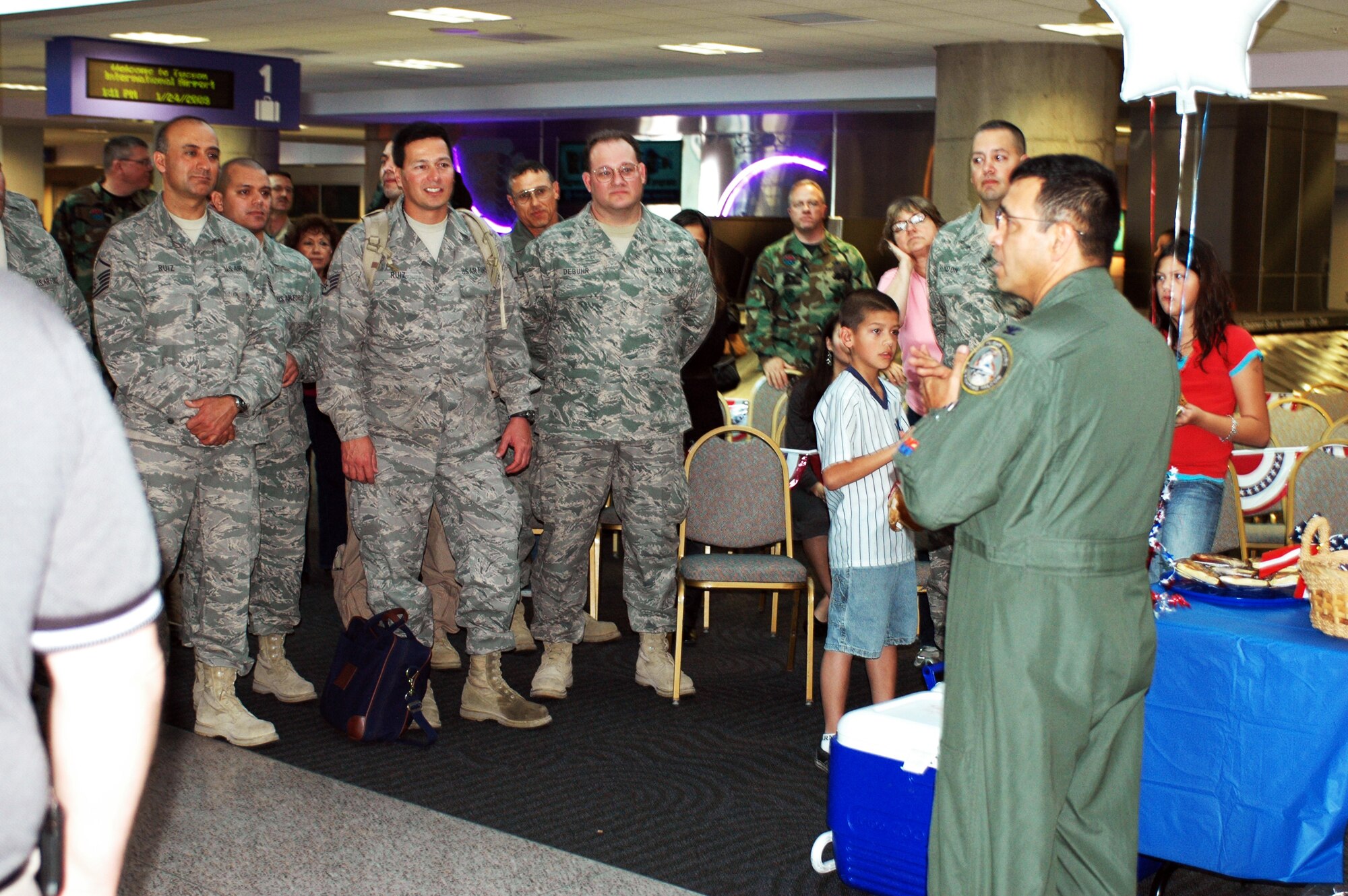 Col. Jose Salinas, wing vice commander, welcomes home the group before departing with their families. Family and friends crowded the baggage claim area at Tucson International Airport to welcome home 28 aircraft maintainers and pilots Jan. 24. The Guardsmen volunteered for tours ranging from 8 months to 30 days in duration. They were given a standing ovation from travelers in the terminal on their way to baggage claim. (Air National Guard photo by Capt. Gabe Johnson)