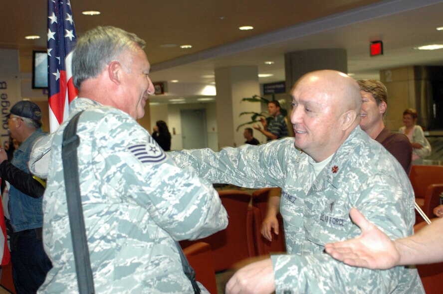 Tech. Sgt. Jaime Aviles is greeted by Chaplain (Maj.) Mike Martinez. Family and friends crowded the baggage claim area at Tucson International Airport to welcome home 28 aircraft maintainers and pilots Jan. 24. The Guardsmen volunteered for tours ranging from 8 months to 30 days in duration. (Air National Guard photo by Capt. Gabe Johnson)