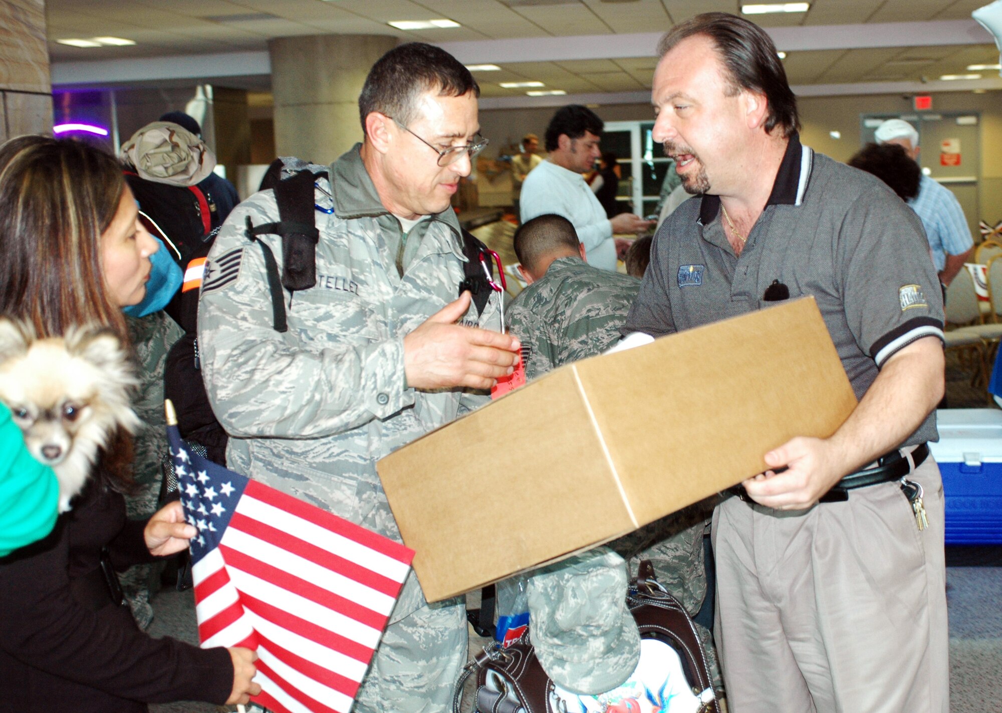 Tech. Sgt. Mike Tellez accepts a box of bread from Rick Cortese of Holsom Bakery Inc. Jan 24 at Tucson International Airport upon his return from Balad Air Base, Iraq. The 162nd Fighter Wing of the Arizona Air National Guard welcomed home Tellez and 27 other aircraft maintainers and pilots after supporting F-16 operations in country. The Arizona baking company gave each returning member a box in appreciation of their service. (Air National Guard photo by Capt. Gabe Johnson)
