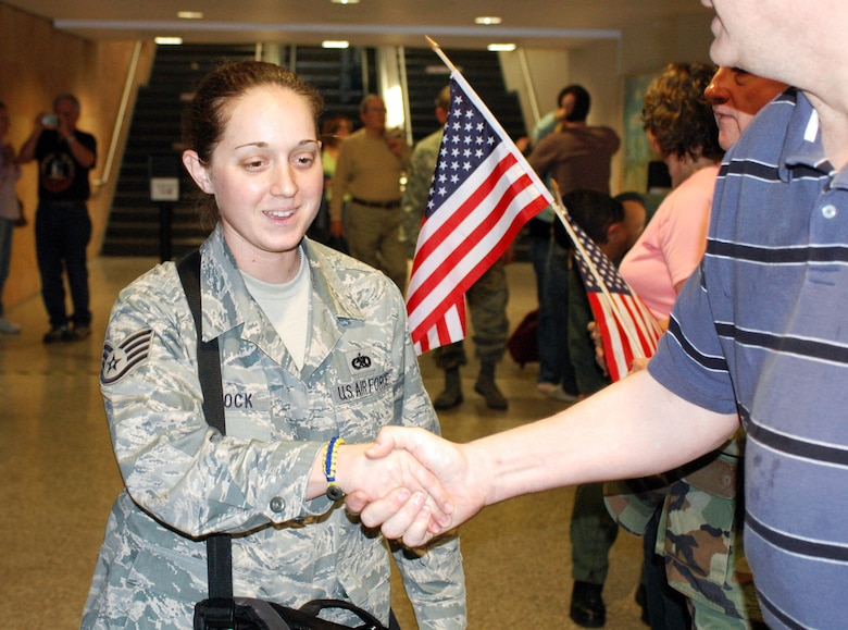 Staff Sgt. Sara Peacock is welcomed home home. Family and friends crowded the baggage claim area at Tucson International Airport to welcome home 28 aircraft maintainers and pilots Jan. 24. The Guardsmen volunteered for tours ranging from 8 months to 30 days in duration. They were given a standing ovation from travelers in the terminal on their way to baggage claim. (Air National Guard photo by Capt. Gabe Johnson)