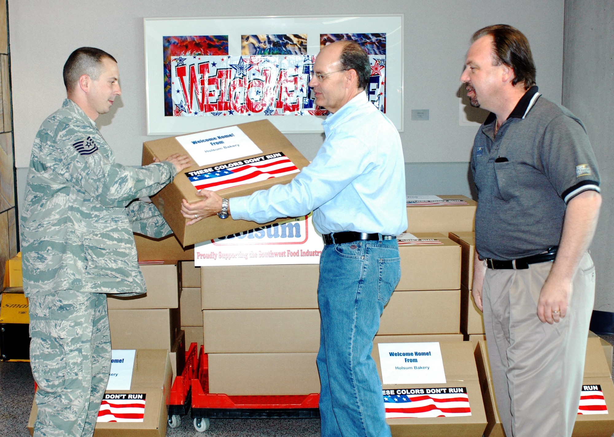 Tech. Sgt. Joe Mazzei accepts a box of bread from Sam Dodson (center) and Rick 
Cortese of Holsom Bakery Inc Jan 24 at Tucson International Airport upon his 
return from Balad Air Base, Iraq. The 162nd Fighter Wing of the Arizona Air 
National Guard welcomed home Mazzei and 27 other aircraft maintainers and 
pilots after supporting F-16 operations in country. The Arizona baking company 
gave each returning member a box in appreciation of their service. (Air 
National Guard photo by Capt. Gabe Johnson)
