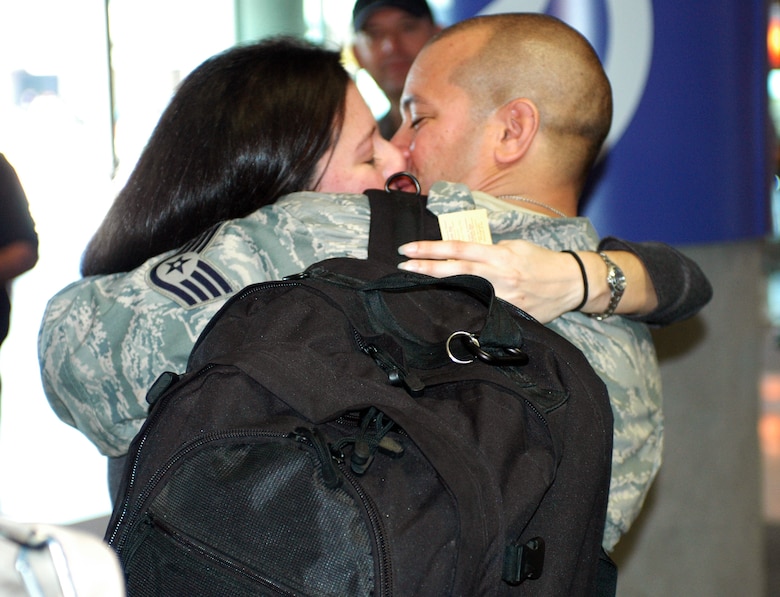 Staff Sgt. Jeremy Raymond kisses his wife Priscilla. Family and friends crowded the baggage claim area at Tucson International Airport to welcome home 28 aircraft maintainers and pilots Jan. 24. The Guardsmen volunteered for tours ranging from 8 months to 30 days in duration. They were given a standing ovation from travelers in the terminal on their way to baggage claim. (Air National Guard photo by Capt. Gabe Johnson)