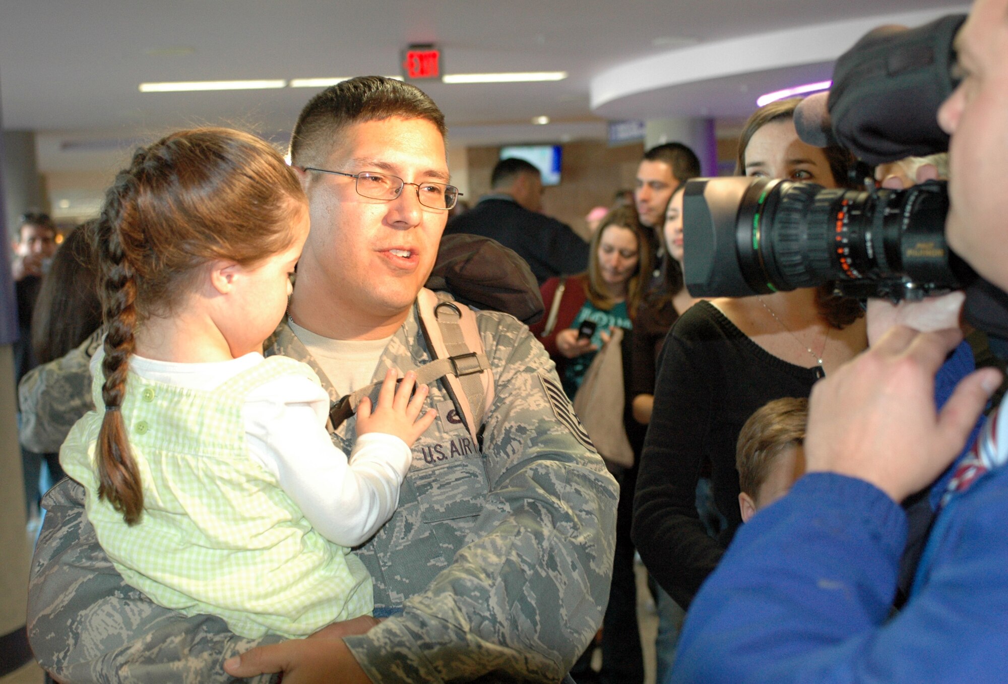 Tech. Sgt. John Sandoval interviews with KVOA Channel 4's Tyler Wing about his deployment for the evening news. Family and friends crowded the baggage claim area at Tucson International Airport to welcome home 28 aircraft maintainers and pilots Jan. 24. The Guardsmen volunteered for tours ranging from 8 months to 30 days in duration. (Air National Guard photo by Capt. Gabe Johnson)