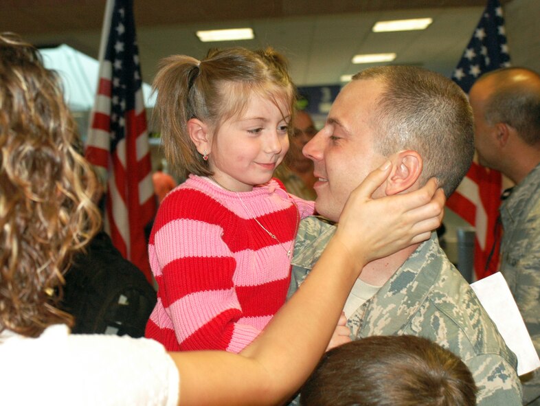 Tech. Sgt. Joe Mazzei hugs his daughter Morgan, 5, upon his return home Jan. 24, after a four-month deployment to Balad Air Base, Iraq. Family and friends crowded the baggage claim area at Tucson International Airport to welcome home 28 aircraft maintainers and pilots. The Guardsmen volunteered for tours ranging from 8 months to 30 days in duration. They were given a standing ovation from travelers in the terminal on their way to baggage claim. (Air National Guard photo by Capt. Gabe Johnson)