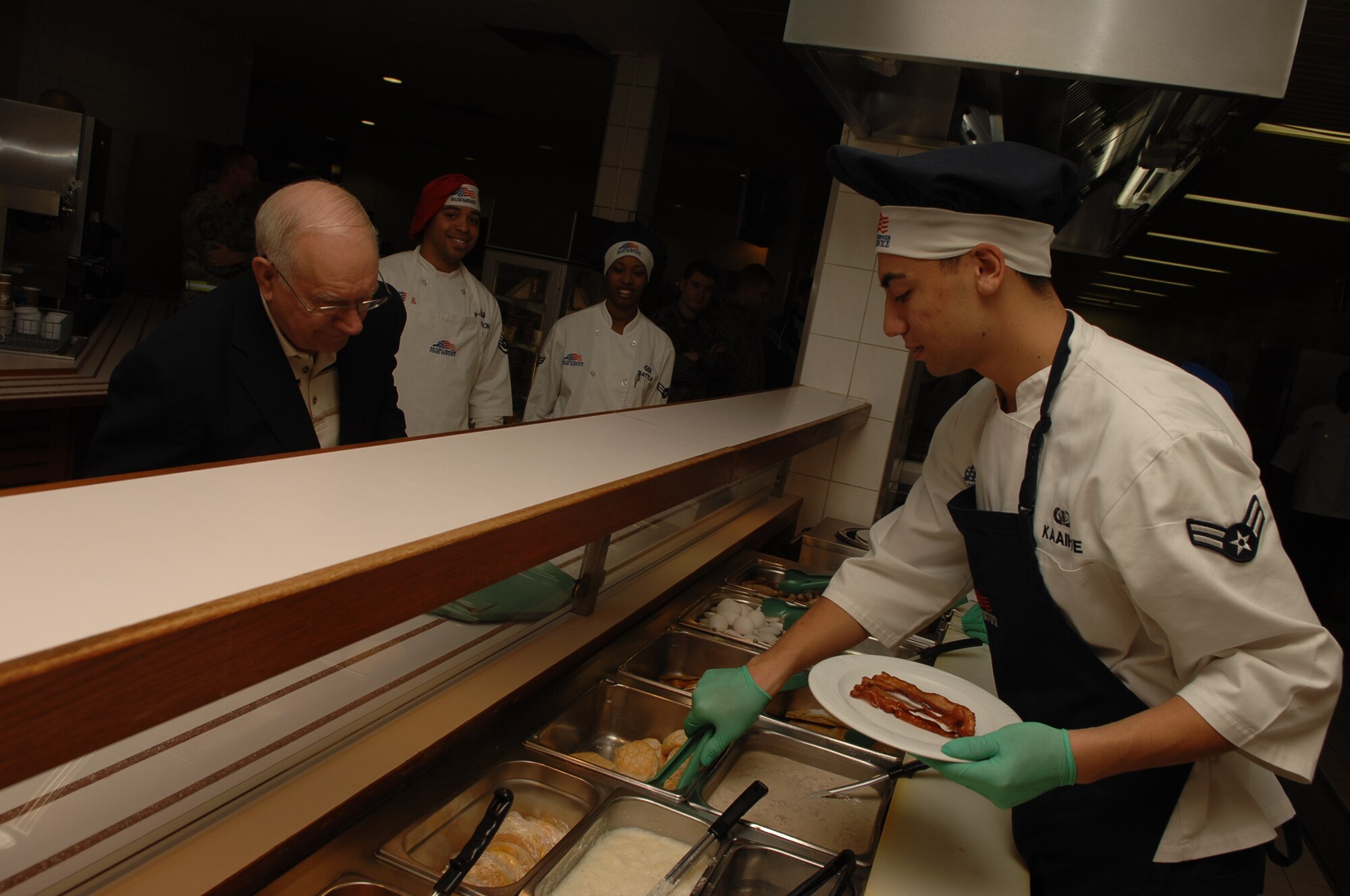 SPANGDAHLEM AIR BASE, Germany – Airman 1st Class Logan Kaaihue, 52 Force Support Squadron, prepares a plate for Sam Parish, 8th Chief Master Sgt. of the Air Force, January 21, 2009.   Chief Parish toured the facilities and answered questions about the past, present and future of the Air Force.  (U.S. Air Force photo by Airman 1st Class Nicholas Wilson)