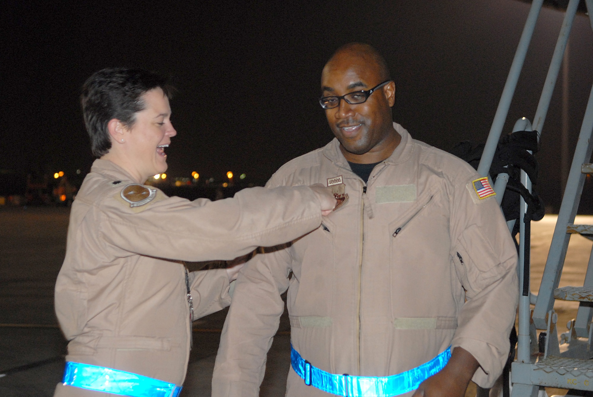 SOUTWEST ASIA - Master Sgt. Terence Jackson, 908 Expeditionary Air Refueling Squadron, receives a 10,000 flight patch from Lieutenant Colonel Jeanette Voigt, 908th EARS commander, Jan 23. As the flight engineer he is the expert for the aircraft systems on the airplane. Sergeant Jackson is deployed from the 305th Air Mobility Wing, McGuire AFB and is from Grand Rapids, Mich. (U.S. Air Force photo by Captain Jennifer M. Pearson) (Released)