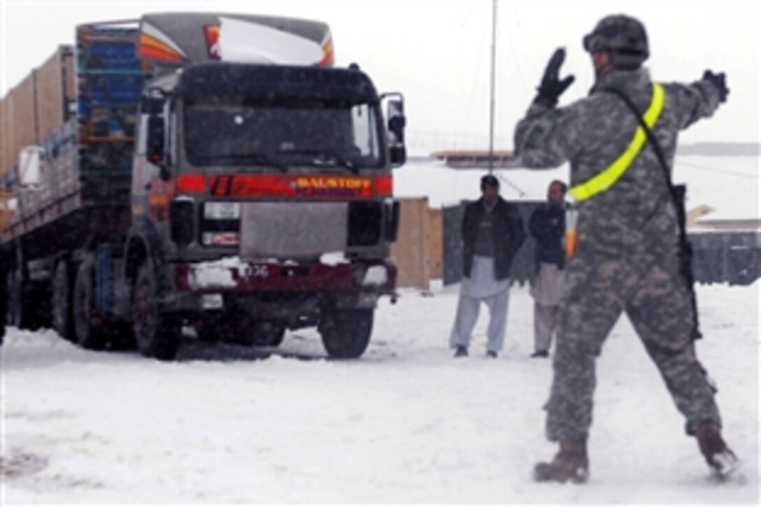 A U.S. Army soldier guides a truck loaded with equipment-filled metal containers on Forward Operating Base Shank, Afghanistan, Jan. 24, 2009. The soldier is assigned to the 10th Mountain Division's 3rd Brigade Combat Team.
