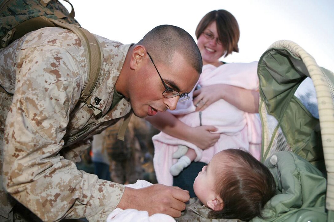 Cpl. Venancio Proa, vehicle mechanic, Headquarters and Service Company, 1st Marine Logistics Group, greets his daughter Serenity while his wife, Elizabeth, watches, during a homecoming ceremony at Camp Pendleton, Sunday. Proa returned home along with about 80 other 1st MLG Marines and sailors following a seven-month deployment to Iraq. Approximately 10,000 service members with the I Marine Expeditionary Force are scheduled to return to Camp Pendleton by spring 2009.