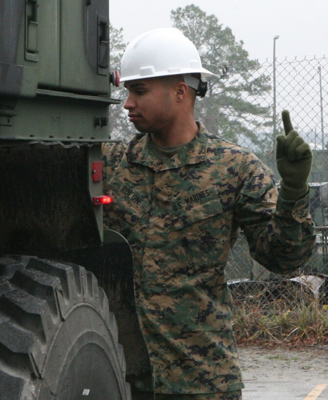 Lance Cpl. Luis Rolon, a motor transportation operator from General Support Motor Transport Company, assists in operating a 7-ton wrecker truck by giving hand signals, here, Jan. 27.  GSMT Marines are working up to upcoming deployments to both Iraq and Afghanistan.