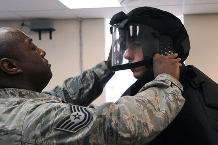 Tech. Sgt. Autry Fontenot, 12th Security Forces Squadron, helps Airman 1st Class Adison Clark don protective gear before participating in TASER training Jan. 20. (U.S. Air Force photo by Rich McFadden)
