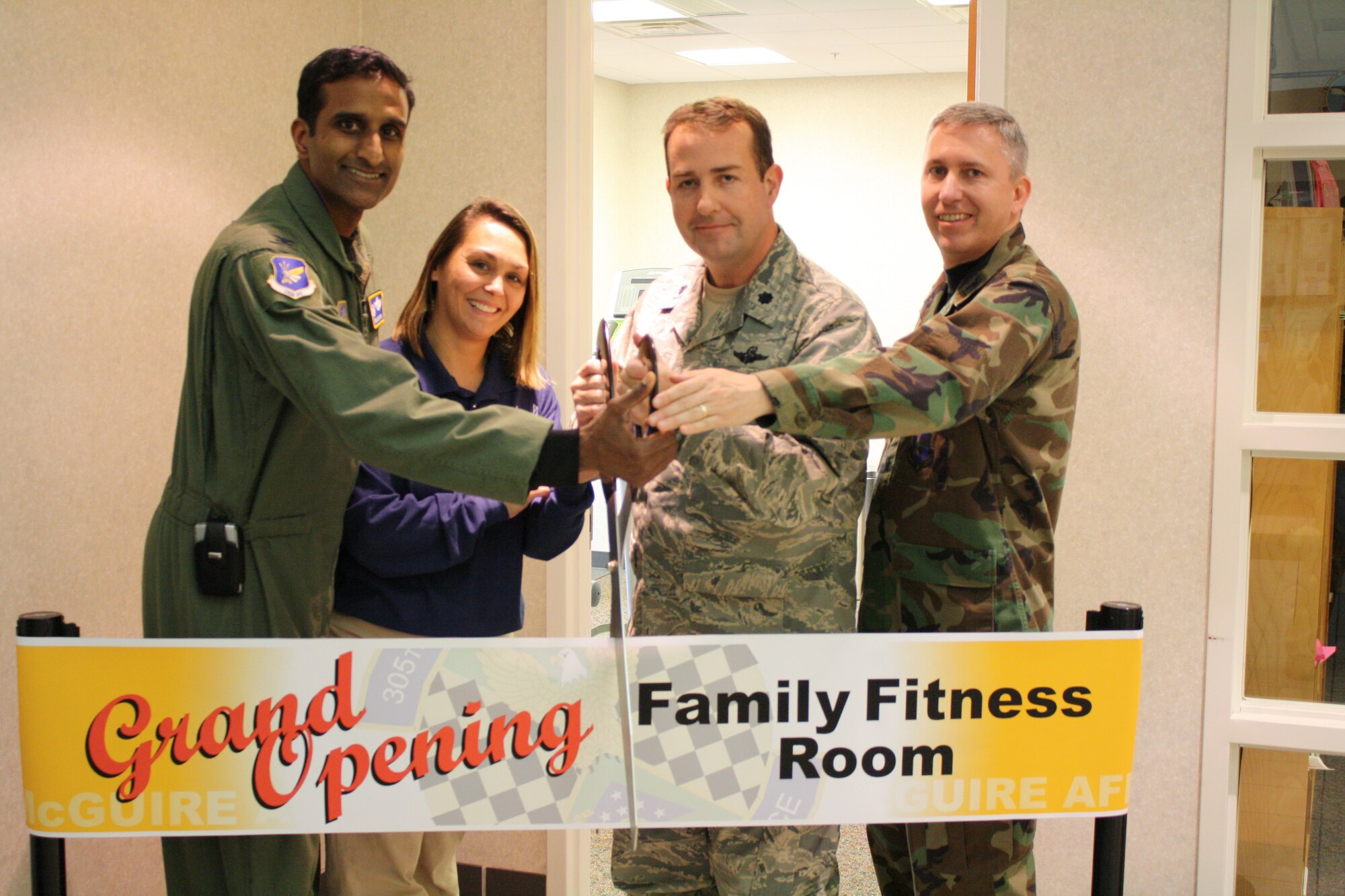 Left to right, Col. Balan Ayyar, 305th Air Mobility Wing commander, Love Vinci, 305th Services Squadron sports director, Lt. Col. John Clark, 305th SVS commander, and Col. Michael Carrell, 305th Mission Support Group commander, cut the ribbon during the opening of the Family Fitness Room Jan. 21. The room, located just inside the fitness center, offers parents (and expecting mothers) the chance to work out while their children play. (U.S. Air Force courtesy photo) 