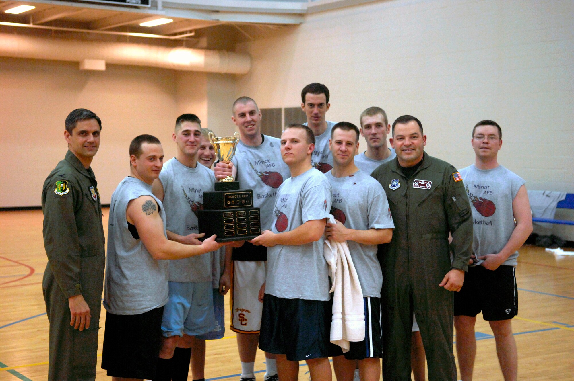 MINOT AIR FORCE BASE, N.D. -- Col. Christopher Ayres, 91st Missile Wing commander, and Col. Steven Basham, 5th Bomb Wing vice commander, pose alongside the 91st Operations Group men’s intramural basketball team after winning the first ever Dakota Cup basketball championship held at the McAdoo Fitness Center here Jan. 23.  The 91st OG defeated the base champions from Grand Forks AFB, N.D., the 319th Communications Squadron, with a final score of 52-46.  The Dakota Cup is a competition between Minot AFB and Grand Forks AFB in the five intramural team sports of football, basketball, volleyball, softball and soccer. (U.S. Air Force photo by Staff Sgt. Keith Ballard)