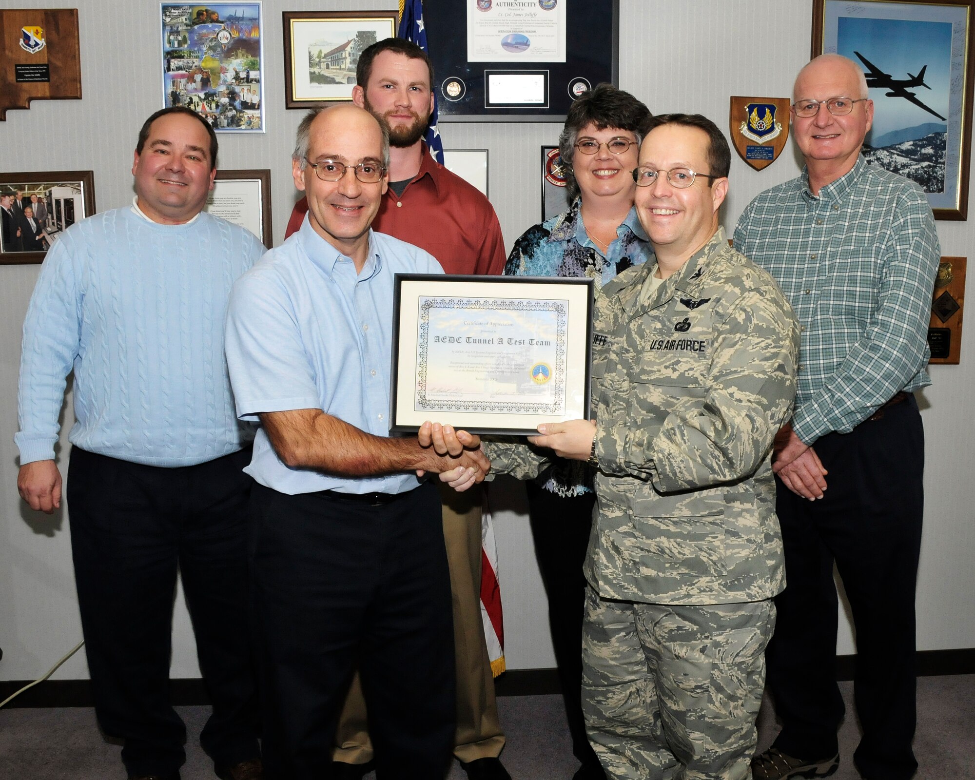 Paul Jalbert, Aerospace Testing Alliance (ATA) project manager, and Col. James Jolliffe, 704th Test Group commander, hold a certificate of appreciation that was presented by NASA for the work done on the NASA Ares Stage Separation Test in VKF Tunnel A in July 2008. According to Jalbert, this test was important to NASA because the stability and control data during the booster and upper stage separation will be used to support the Ares I-X flight later this year. Pictured from left to right: Back row, from left, Lyle Sissom, instrumentation engineer, Kevin Boyce, test operations engineer, Janet Feller, programming and data reduction and Win Phipps, AEDC Air Force project manager. ATA is the support contractor for AEDC. (Photo by Rick Goodfriend)