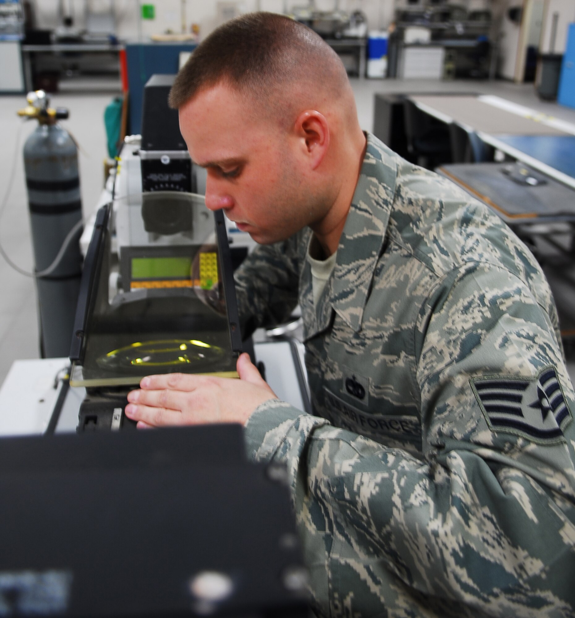 Staff Sgt. Matthew Wuntke, 56th Component Maintenance Squadron avionics team leader, inspects the heads up display combinder glass for defects January 26 in the AIS back shop. The HUD shows images on the combinder glass which the pilot can then see. (Air Force photo by Staff Sgt. Phillip Butterfield)