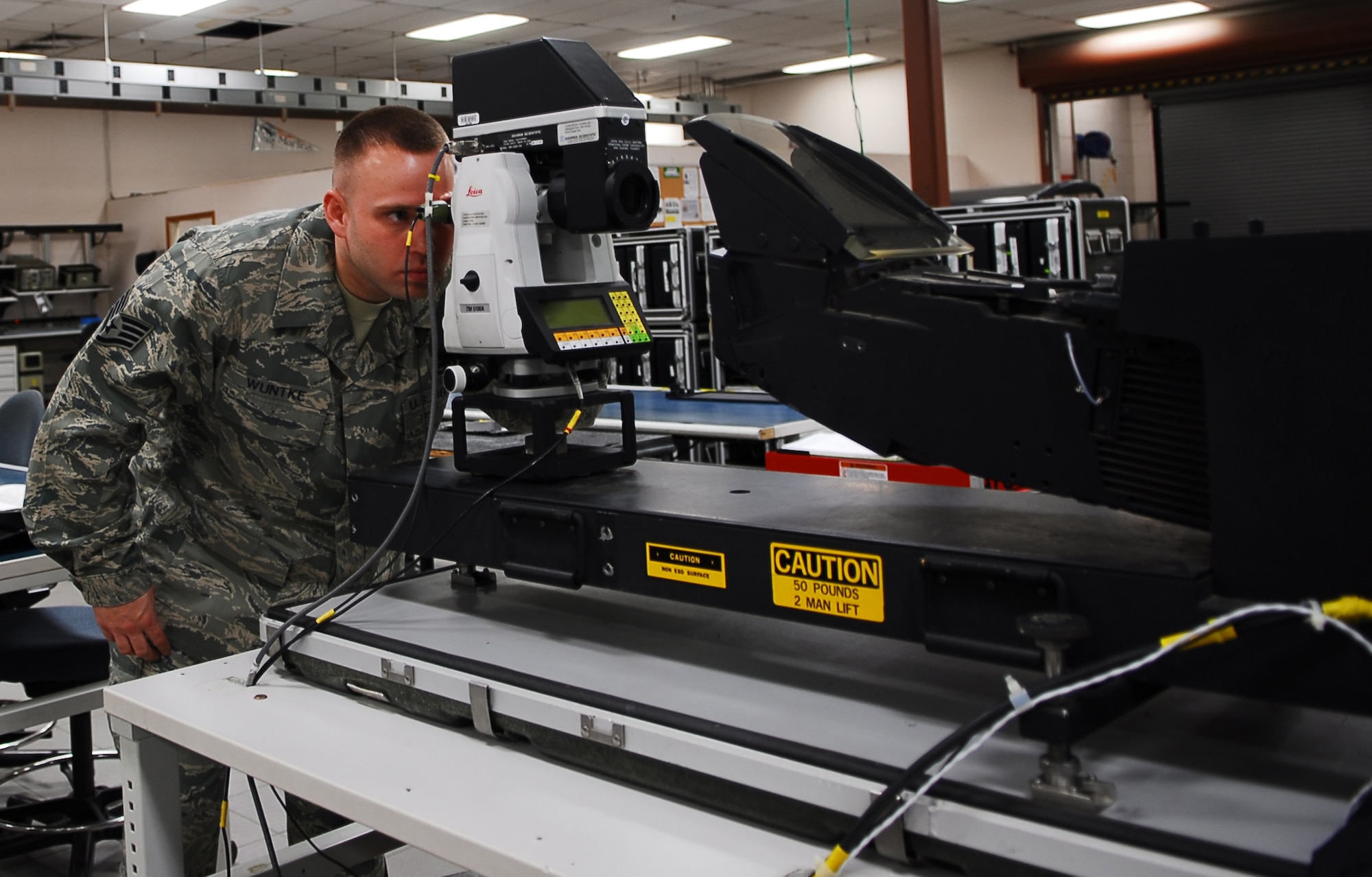 Staff Sgt. Matthew Wuntke, 56th Component Maintenance Squadron avionics team leader, sights through an optical measuring device to test a heads up display January 26 in the AIS back shop. The HUD is the primary display used to give the pilot information while in flight. (Air Force photo by Staff Sgt. Phillip Butterfield)