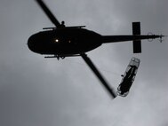 A “stokes litter” carrying an accident victim is hoisted up to a UH-1N Huey helicopter from the 40th Helicopter Squadron.  Once the patient is on board the aircraft, a flight surgeon or flight nurse can perform a life-saving role while en route to a local hospital or care facility for treatment. At Malmstrom, flight surgeons and flight nurses are required to accomplish one day and one night hoist per calendar year for training.  (U.S. Air Force photo/Capt. David Oettel)