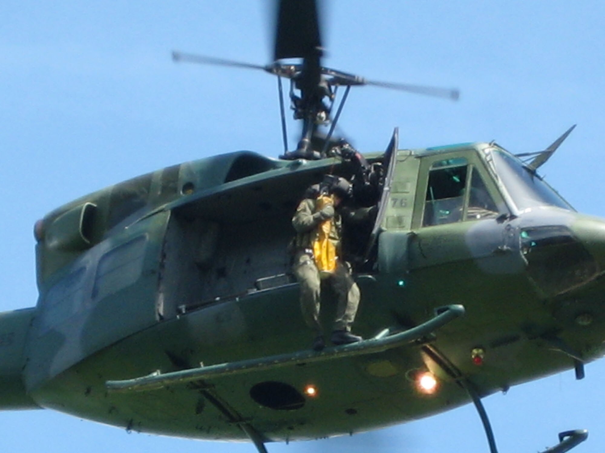 Capt. Mitchell Parrish, 341st Medical Operations Squadron flight surgeon, gets a lift from a UH-1N Huey helicopter from the 40th Helicopter Squadron. Captain Parrish is hoisted up 120 feet sitting on a “force penetrator” while participating in a search and rescue exercise in May 2008. At Malmstrom, flight surgeons and flight nurses are required to accomplish one day and one night hoist per calendar year for training.  (U.S. Air Force photo/Capt. David Oettel)