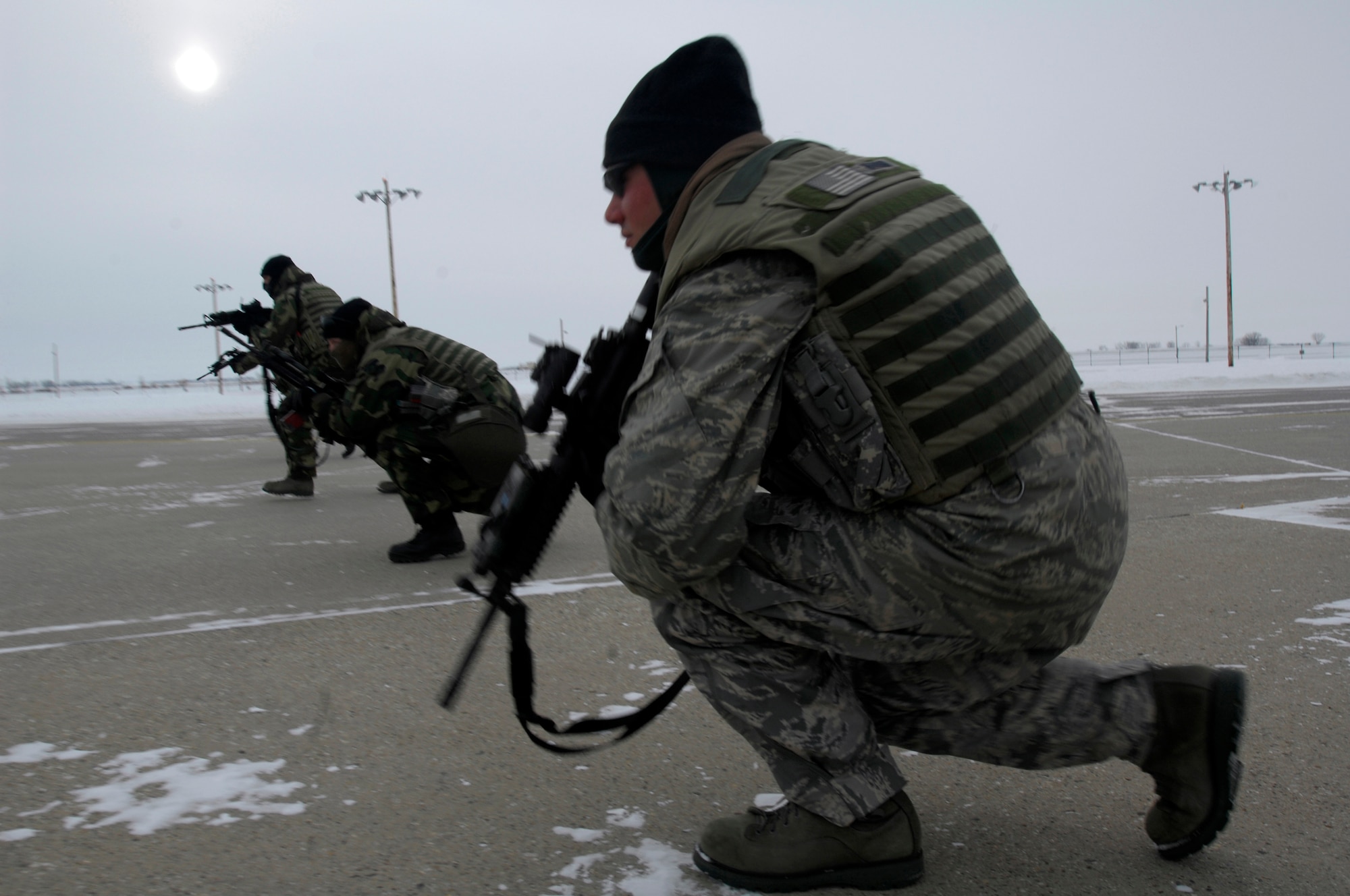 MINOT AIR FORCE BASE, N.D. -- 5th Security Forces members endure the harsh cold during a Blue Coach Training Initiative training scenario here Jan 8. U.S. Navy SEALs will help train a total of 200 Minot AFB security forces members on recapturing and combat tactics by the end of April. (U.S. Air Force photo by Airman 1st Class Jesse Lopez)