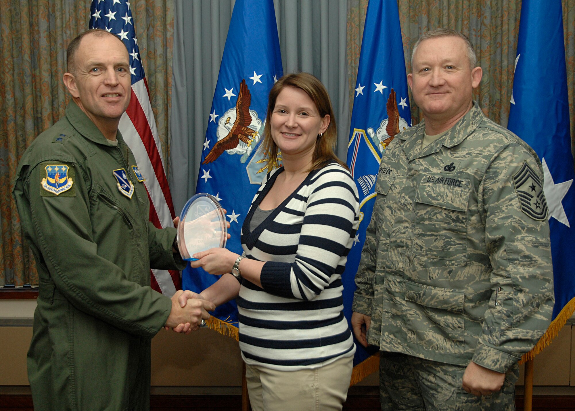Air Force District of Washington Civilian of the Quarter (CAT III) , Ms. Jennifer N. Weatherly, accepts her  award from AFDW Commander Maj. Gen. Ralph Jodice, and AFDW Command Chief, Chief Master Sgt. Paul Wheeler, during the AFDW Quarterly Awards Ceremony, held Jan. 22 at the Andrews Air Force Base club. Ms. Weatherly works in AFDW/A6PRM. 