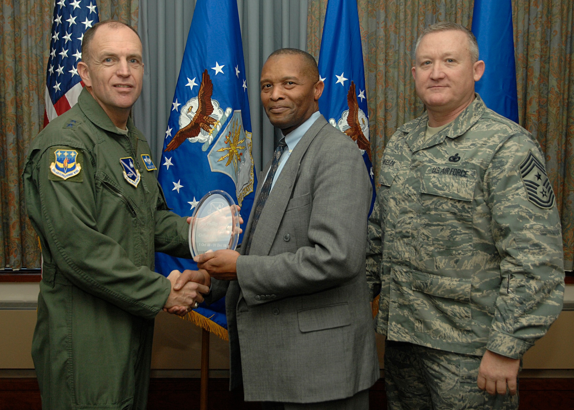 Air Force District of Washington  Civilian of the Quarter (CAT II) –  Mr. Phillip A. Henry, AFDW/A8AO-P  accepts his  award from AFDW Commander Maj. Gen. Ralph Jodice, and AFDW Command Chief, Chief Master Sgt. Paul Wheeler, during the AFDW Quarterly Awards Ceremony, held Jan. 22 at the Andrews Air Force Base club. Captain Hristov works in the AFDW Legal Office. 