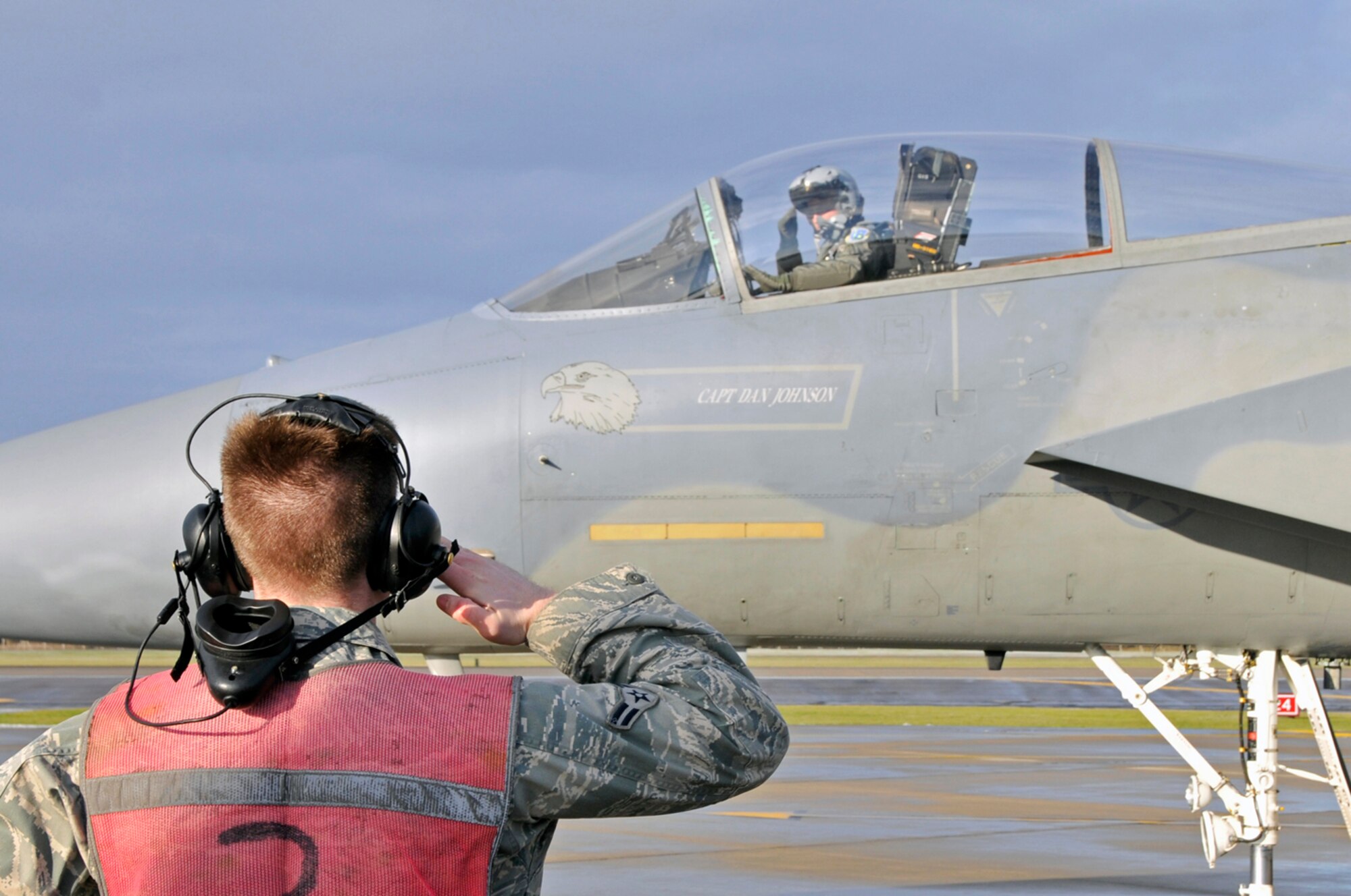 Airman 1st Class Aaron Serviss, 48th Aircraft Maintenance Squadron, F-15 Eagle crew chief, salutes a pilot just returning home from a three-month deployment Jan. 5 at RAF Lakenheath, England. The 493rd Fighter Squadron had just returned from Lithuania, after being deployed there for three months to participate in the NATO Baltic Air Policing mission. (U.S. Air Force photo by Airman 1st Class Perry Aston)