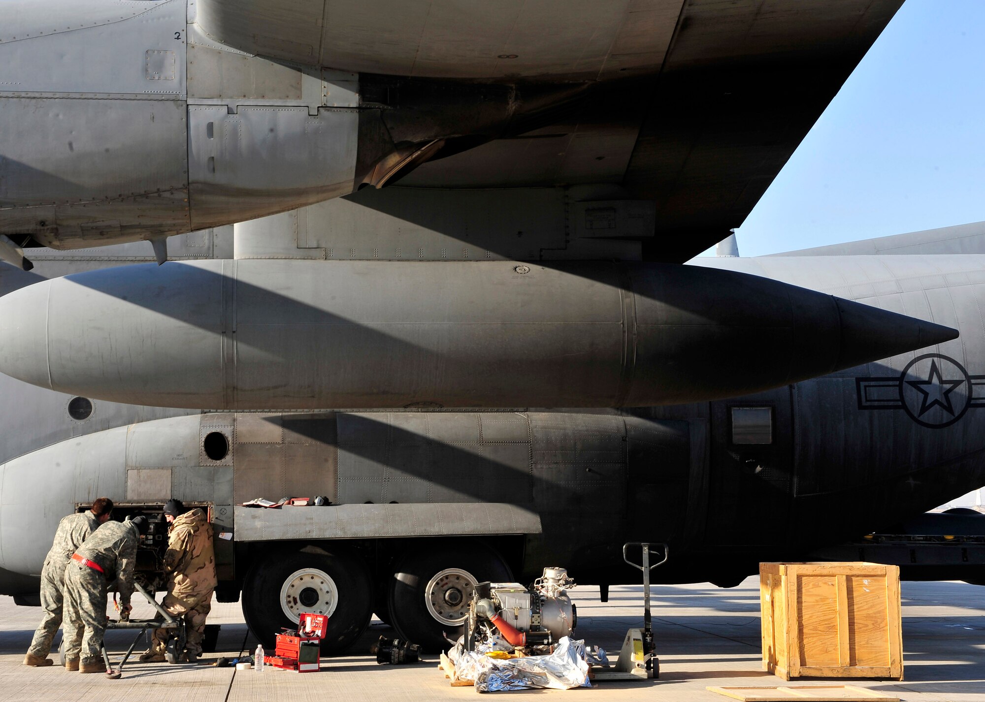 Technical Sgt. Sam Harmon, Senior Airman Billy Howell and Airman 1st Class Ryan Sluss change an auxiliary power unit of a C-130 Hercules Jan. 16 at Joint Base Balad, Iraq. Sergeant Harmon and Airman Howell are 777th Expeditionary Aircraft Maintenance Unit jet engine mechanics. Airman Sluss is a 777th EAMU crew chief. They are all deployed from Little Rock Air Force Base, Ark. (U.S. Air Force photo/Senior Airman Elizabeth Rissmiller) 
