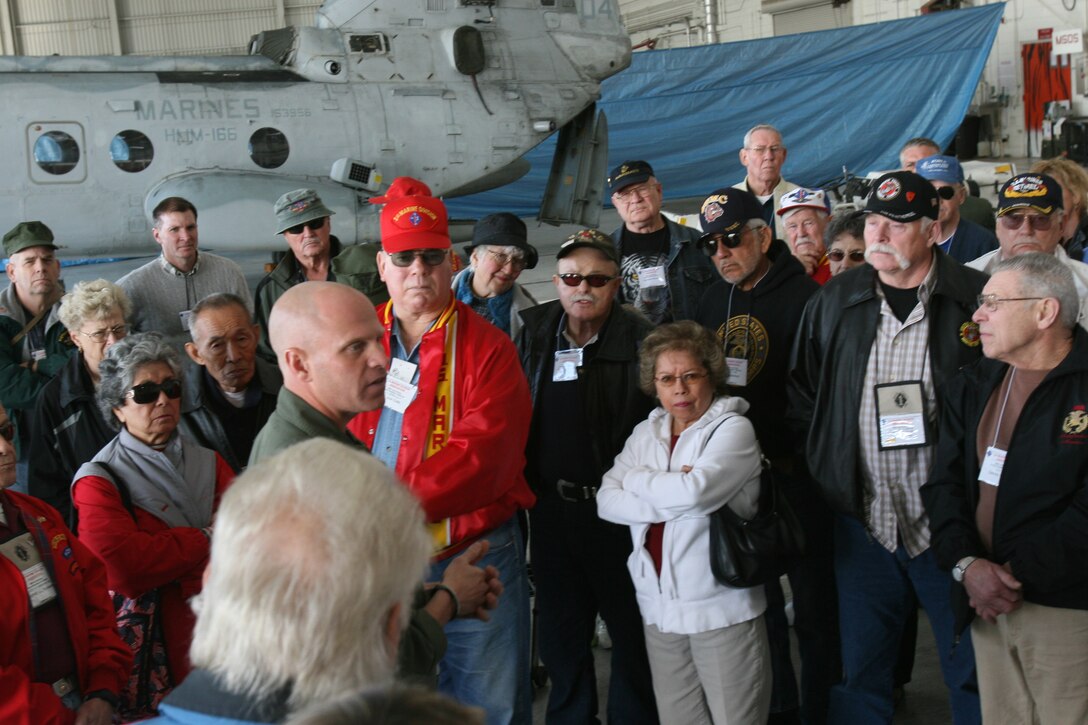 Gunnery Sgt. Bryan K. Cox, the flight line division chief with Marine Heavy Helicopter Squadron 361, Marine Aircraft Group 11 (Reinforced), 3rd Marine Aircraft Wing, speaks to Marine veterans from World War II, Korea and Vietnam during their visit to Marine Corps Air Station Miramar, Jan. 27. The squadron gave the veterans a tour of a CH-53E ?Super Stallion? and answered their many questions about Marine aviation.   (U.S. Marine Corps photo by Lance Cpl. Christopher O'Quin) (Released)