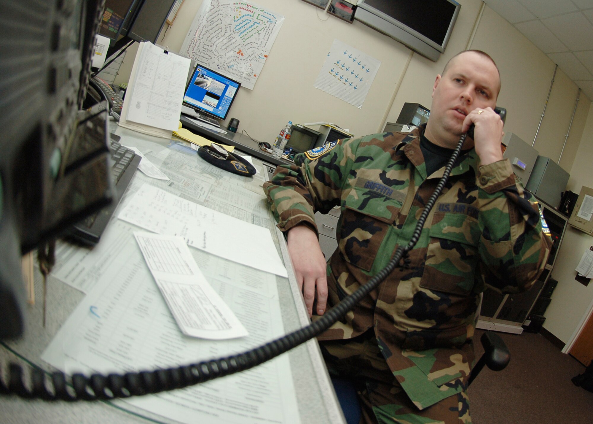 MCCONNELL AIR FORCE BASE, Kan. -- Jason Griffith, 22nd Security Forces Squadron, answers a call at the McConnell Emergency Command Center, Jan. 28. Security forces personnel work alongside the fire department dispatchers to expedite emergency calls. (Photo by Airman 1st Class Maria Ruiz)