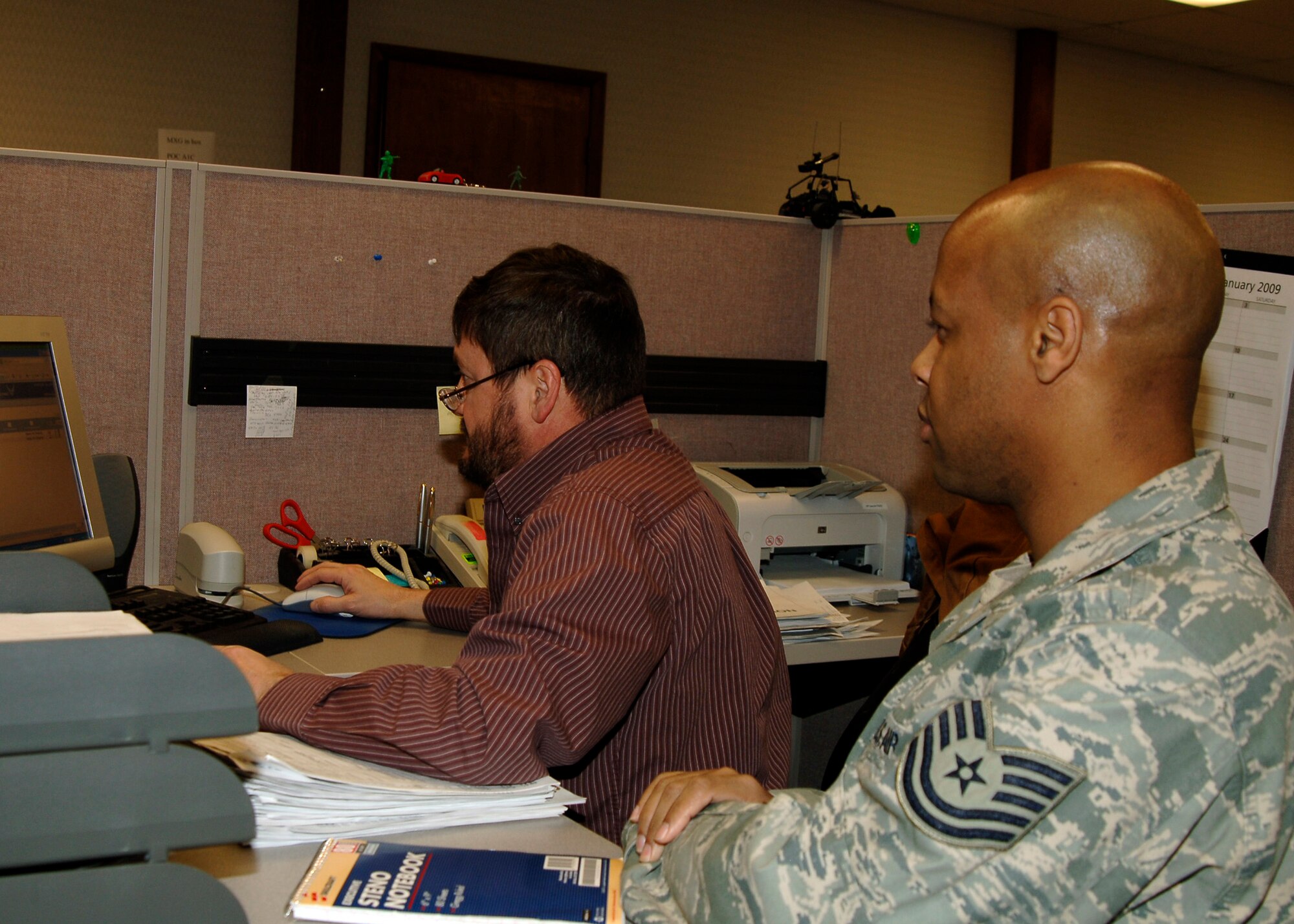 MCCONNELL AIR FORCE BASE, Kan. --Tech. Sgt. Brian Williamson and Jan Dunlavy, 22nd Comptroller Squadron financial management, check the status of a travel voucher at the finance office, Jan. 27. Finance staff double checks travel vouchers to see when they are going to be processed for accountability purposes. (Photo by Senior Airman Anthony Mejia)