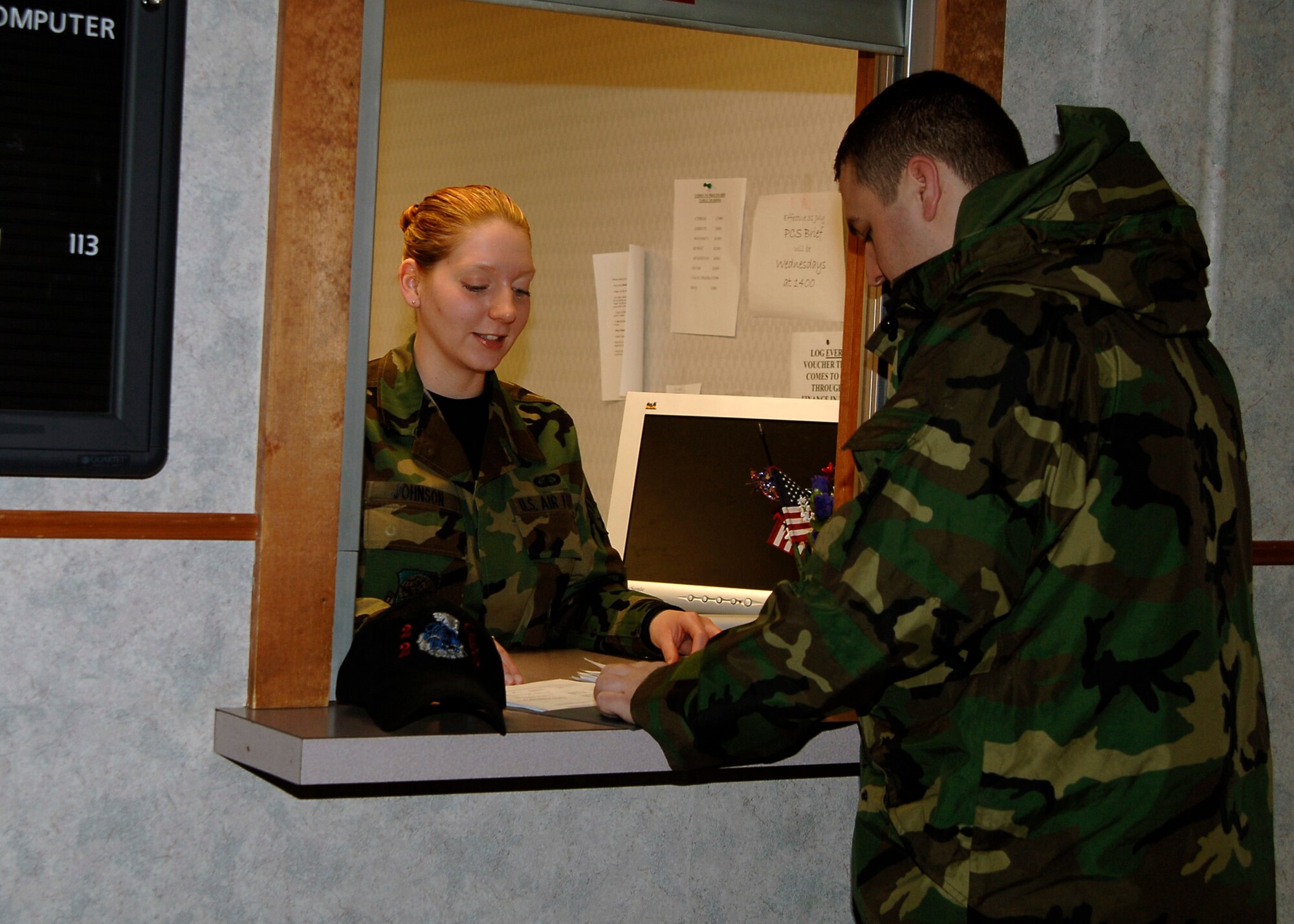 MCCONNELL AIR FORCE BASE, Kan. --Senior Airman Jessica Johnson, 22nd Comptroller Squadron financial management, assists Senior Airman Lucas Temmen, 22nd Civil Engineer Squadron firefighter, with his travel voucher at finance customer service, Jan. 27. Personnel returning from temporary duty assignment, permanent change of station or deployments have their travel vouchers checked over with finance to ensure everything is correct before processing. (Photo by Senior Airman Anthony Mejia)
