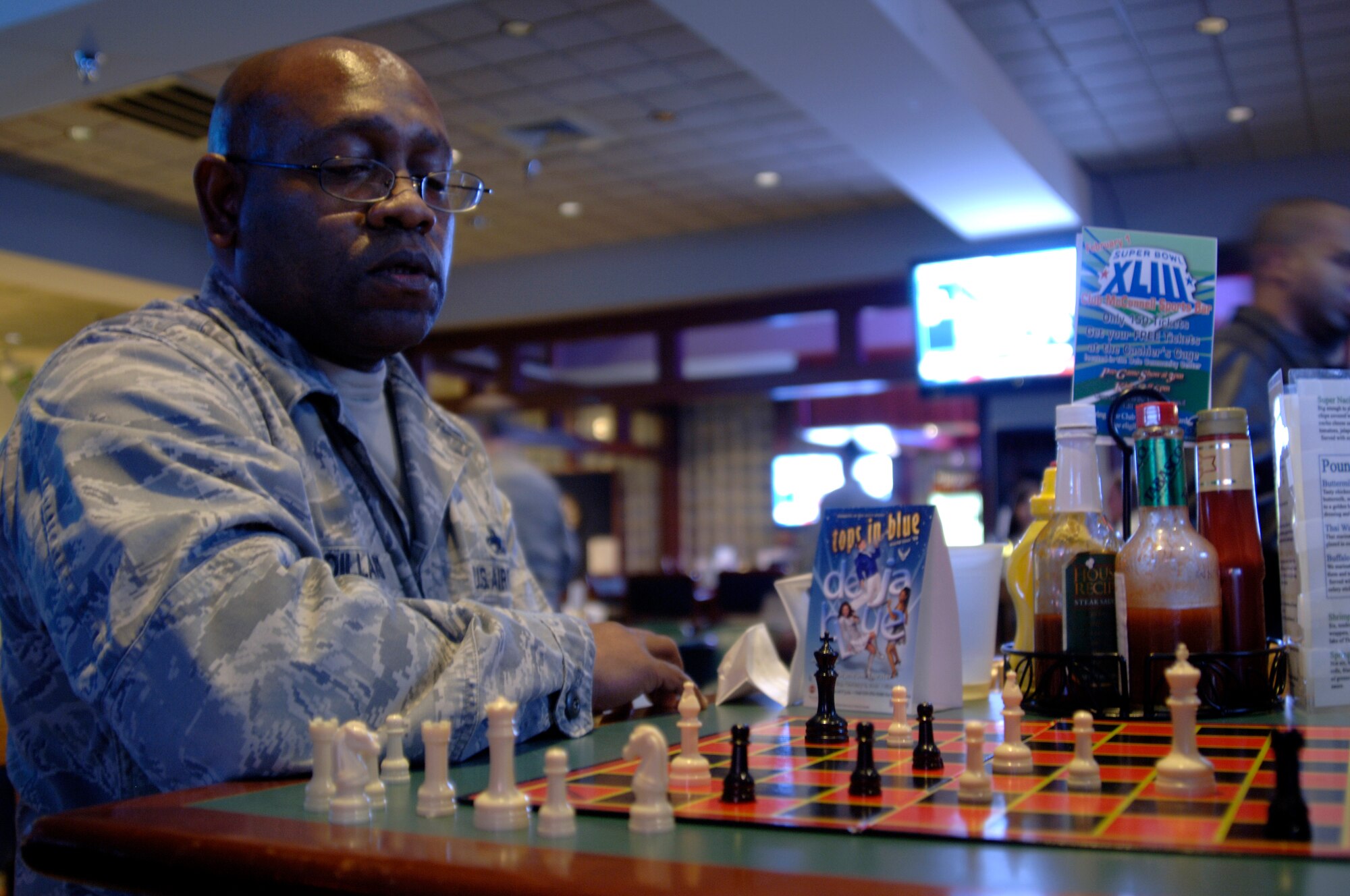 MCCONNELL AIR FORCE BASE, Kan. -- Col. Michael Dillard, 22nd Maintenance Group commander, battles Senior Airman John Fliszar, 931st Air Refueling Group, in a game of chess during Boss and Buddy at Club McConnell, Jan. 23. Boss and Buddy is a time for supervisors to interact with their Airmen in a social environment. Popular activities include eating, playing pool or other games and conversation. (Photo by Senior Airman Laura Suttles)