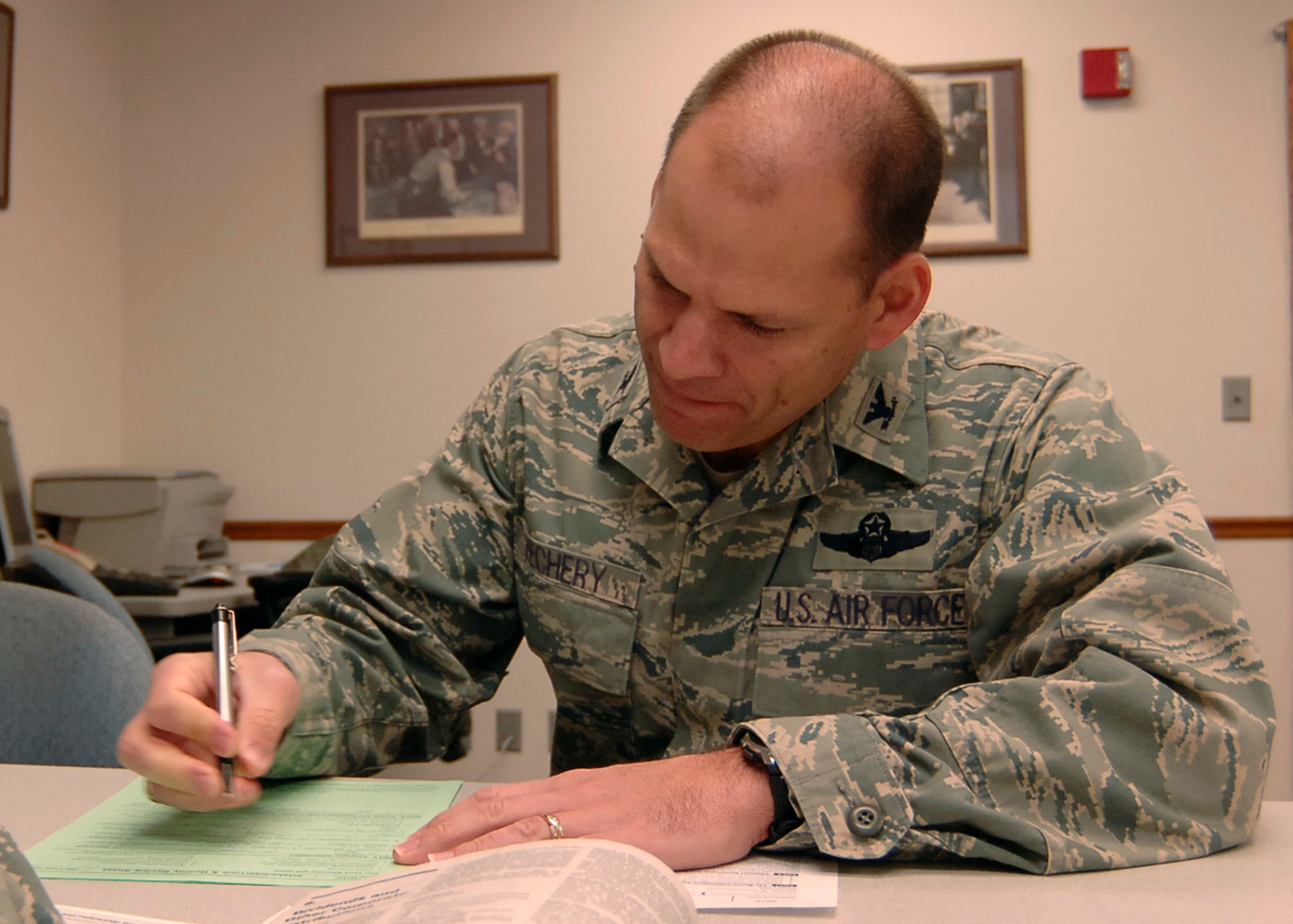 MCCONNELL AIR FORCE BASE, Kan. -- Col. James C. Vechery, 22nd Air Refueling Wing commander, fills out the Intake/Interview and Quality Review sheet for his tax preparation at the legal office, Jan. 23. Last year the tax center prepared more than 892 returns and saved over $1.6 million on tax return fees. The tax center will be available until April 15th. (Photo by Airman 1st Class Maria Ruiz)