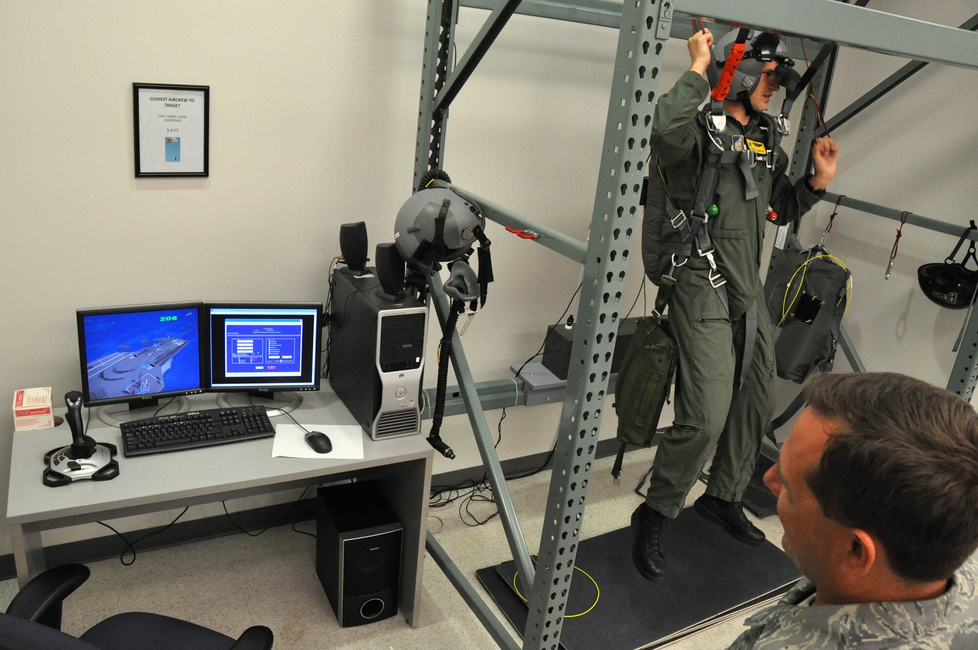 Tech Sgt. Sherwood Brown watches as Maj. Will Martin, a pilot with the 535th Airlift Squadron at Hickam Air Force Base, Hawaii, guides his virtual parachute as he attempts to land on an aircraft carrier during a refresher parachute training class Jan 24.  Aircrews require annual non-ejection parachute training so they are current according to Air Force instructions.  Sergeant Brown is a survival, evasion, resistance, escape, or SERE, instructor with the 15th Airlift Wing at Hickam.  (U.S. Air Force photo/Tech. Sgt. Cohen A. Young)