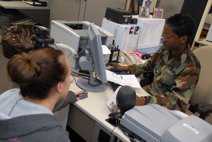 Airman 1st Class Eboni Brown scans Staff Sgt. Aubrey Arnold's fingertip for an inactive reserve identification card at the 437th Force Support Squadron Military Personnel Flight Jan. 28. Members of the ID card section update more than 300 ID cards on a weekly basis. Airman Brown is with the 437th Force Support Squadron and Sergeant Arnold is separating from the Air Force and is here with her husband, Staff Sgt. Curtis Arnold, from the 437th Operations Support Squadron. (U.S. Air Force photo/Airman 1st Class Melissa White)