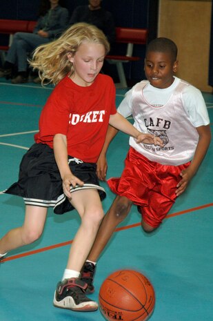 Alex Jackson, left, runs the ball down court as Nick Tolbert, right, plays defense during the youth basketball game at the Youth Programs gym Jan. 27. Charleston AFB 1 Eagles defeated the Hannah Rockets 23-15. Alex, Hannahan Rockets, is the son of Che Jackson. Nick, Charleston AFB 1 Eagles, is the son of Nicole Tolbert from the Naval Weapons Station, Charleston. (U.S. Air Force photo/Staff Sgt. Marie Cassetty)
