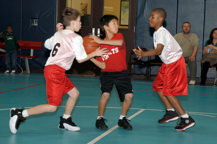 Sammy Palmer prepares to shoot as Derrick Daniel, left, and Isaiah Washington, right, prepare to block the shot during the youth basketball game at the Youth Programs gym Jan. 27. Charleston AFB 1 Eagles defeated the Hannah Rockets 23-15. Sammy, Hannahan Rockets, is the son of Eddie Palmer. Derrick, Charleston AFB 1 Eagles, is the son of Kevin and Master Sgt. Sieghild Daniel who is assigned to the 437th Operation Support Squadron. Isaiah, Charleston AFB 1 Eagles, is the son of Master Sgt. Charles Washington who is assigned to the 437th Airlift Wing Legal Office. (U.S. Air Force photo/Staff Sgt. Marie Cassetty)
