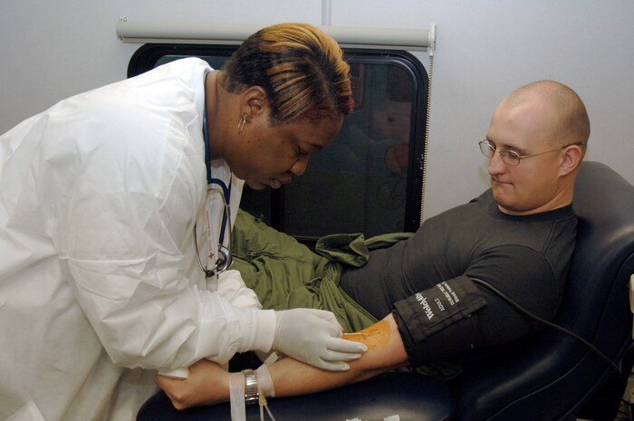 Tomeka Franklin inserts the needle into the arm of Staff Sgt. Ray Green during an American Red Cross blood drive held in the Home Station Check hangar Jan. 23. Thirty-four Team Charleston members participated in the blood drive to donate a total of thirty-eight pints of red cell blood and whole blood. Mrs. Franklin is a certified medical assistant with the ARC and Sergeant Green is assigned to the 437th Operations Support Squadron. (U.S. Air Force photo/Staff Sgt. Marie Cassetty)