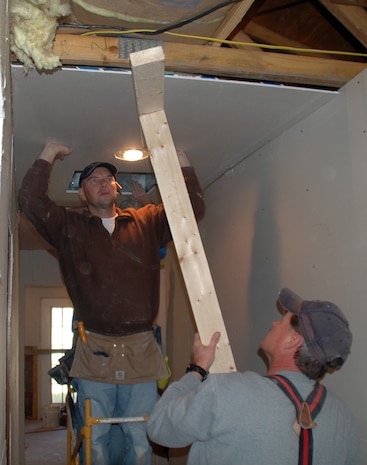 Master Sgts. Shawn Delp and Peter Shovey install sheetrock in a newly widened hall at the home of Master Sgt. Don Eagle. Members of Charleston AFB have been working on Sergeant Eagle?s house since November to make it handicap accessible. Sergeants Delp and Shovey are assigned to the 300th Airlift Squadron. (U.S. Air Force photo/Capt. Wayne Capps)