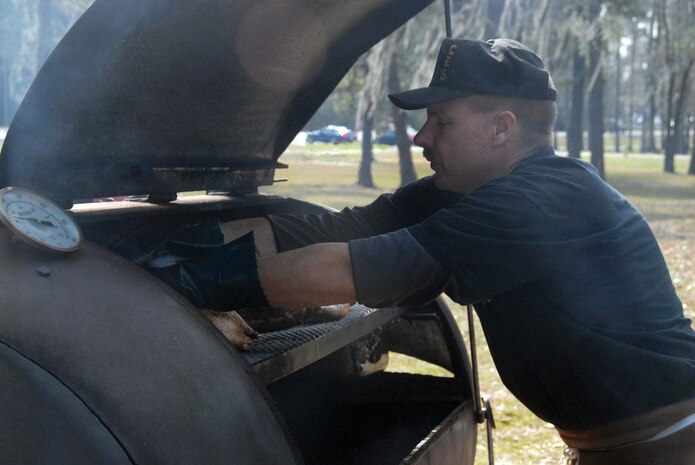Senior Master Sgt. Brian Davis cooks chicken for the Top 3 barbeque lunch fundraiser at the base picnic grounds Jan. 23. The Top 3 raised $3,729 for the Master Sgt. Don Eagle Fund to help with the cost of remodeling his home to make it handicap accessible. Sergeant Davis is with the 437th Civil Engineer Squadron. (U.S. Air Force photo/Airman 1st Class Melissa White)