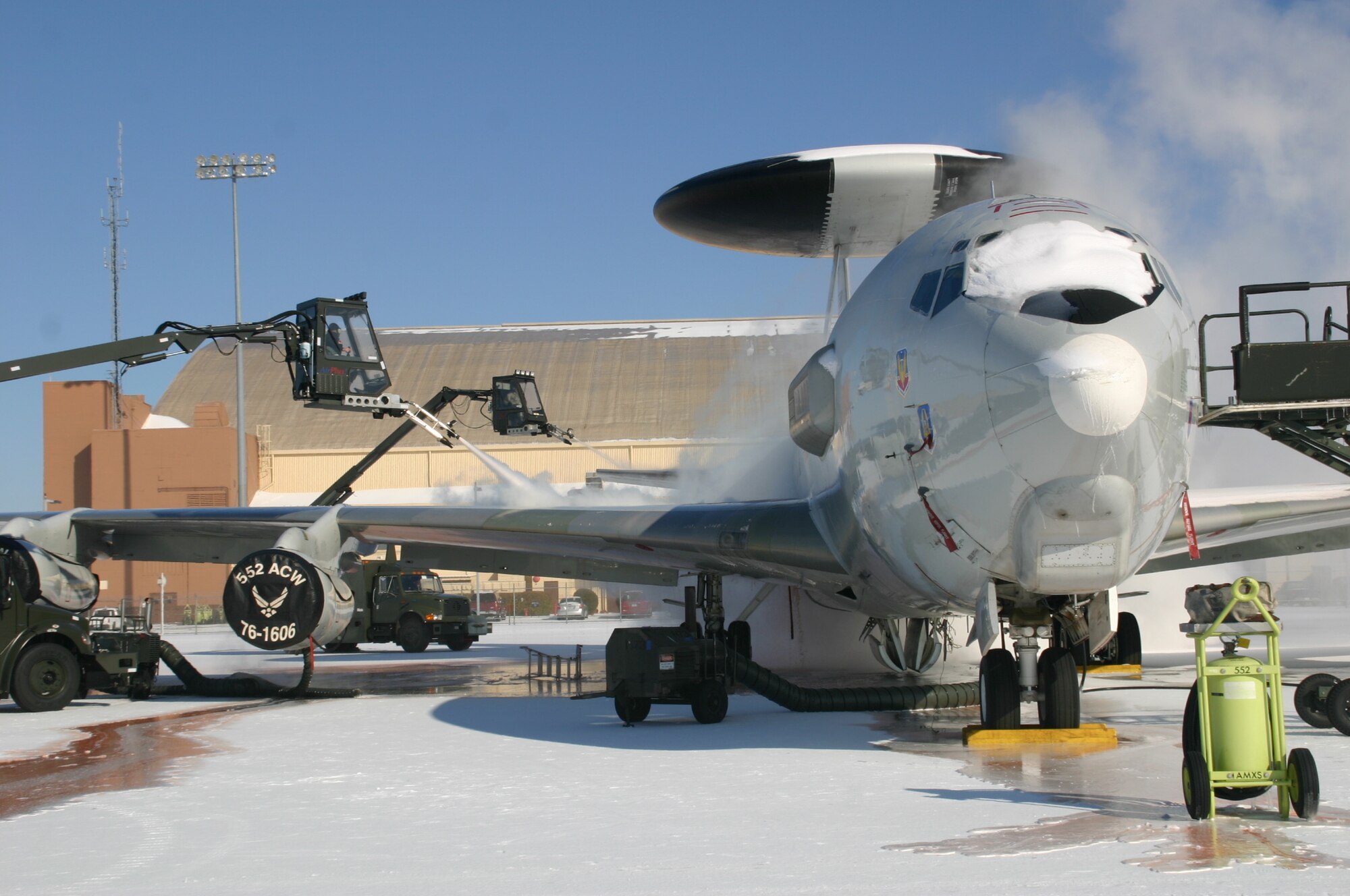 Operations must go on! The 552nd Air Control Wing doesn’t let the ice and snow hold up the mission. Crews are hard at work de-icing the jets and working to get the runways suitable for use. Photo courtesy of 1Lt. Kinder Blacke.