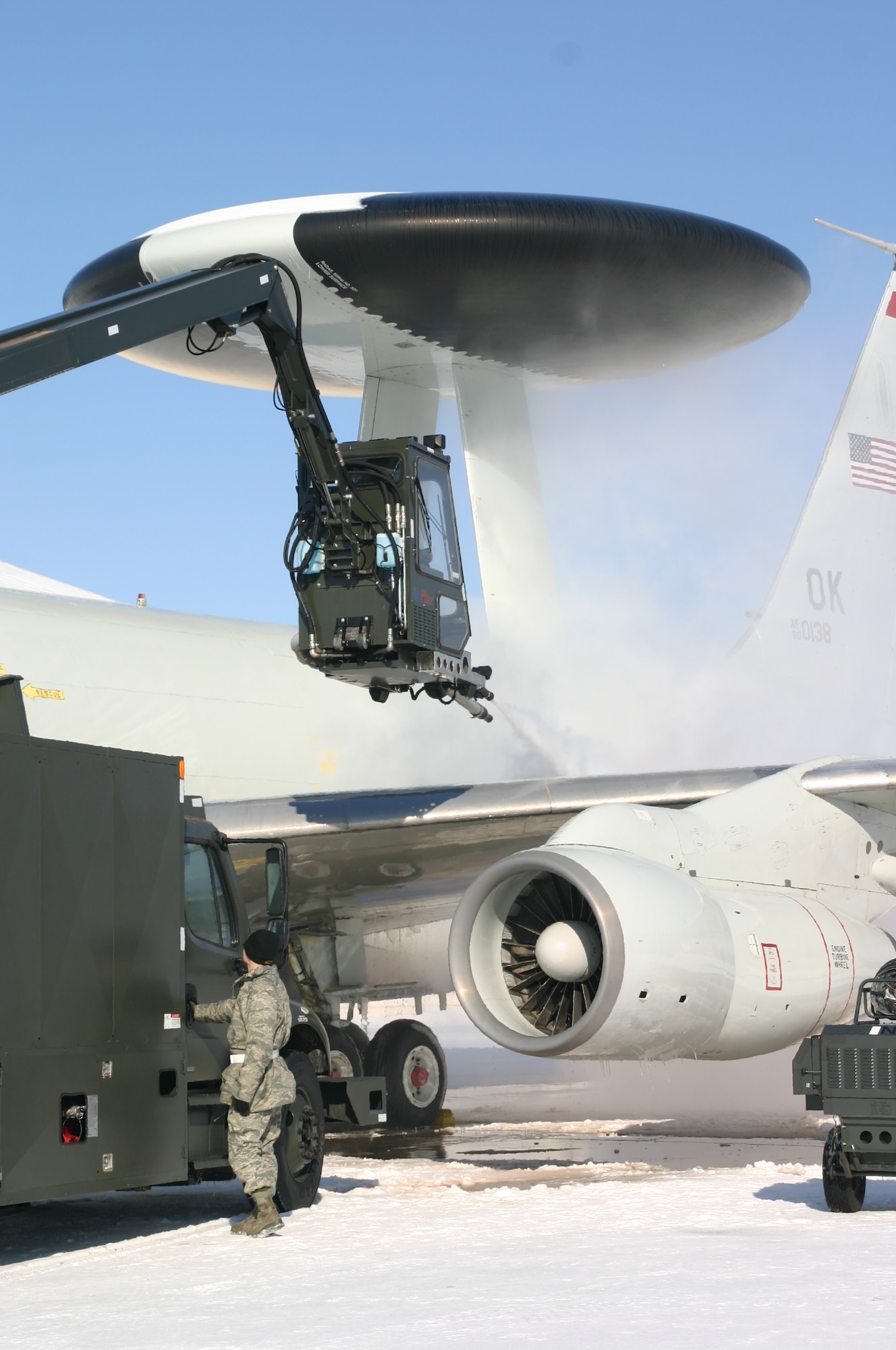 Operations must go on! The 552nd Air Control Wing doesn’t let the ice and snow hold up the mission. Crews are hard at work de-icing the jets and working to get the runways suitable for use. Photo courtesy of 1Lt. Kinder Blacke.