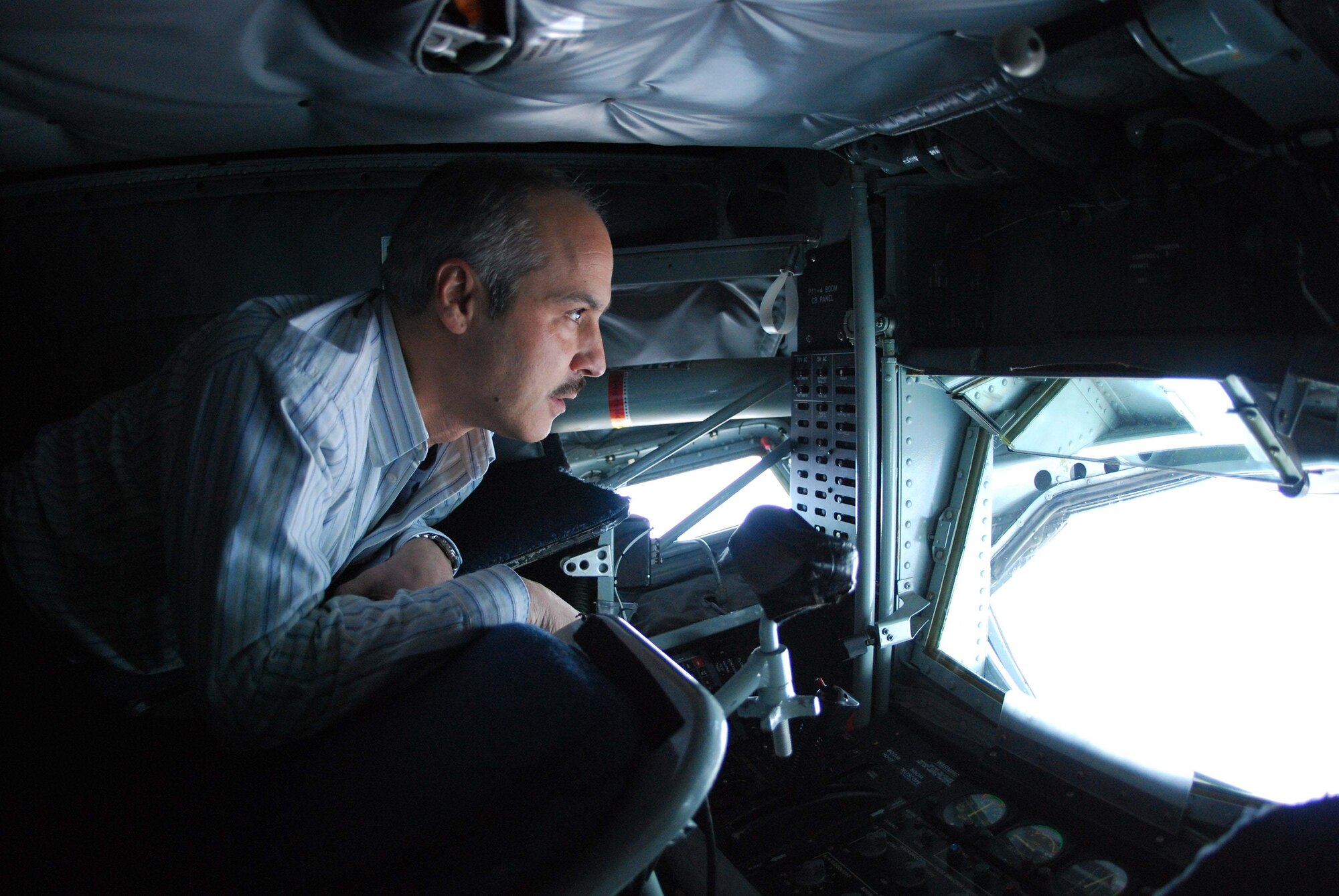 Lou Gambino, a senior advisory engineer for the Northrop Grumman Corporation, patiently waits in the "boom pod" for arriving F-16 fighter jets where the boom operator will take control to dispense fuel.  Mr. Gambino is an employer of Chris Sheppard, 113th Wing, District of Columbia Air National Guard pilot, who is flying one of the fighter jets arriving for fuel.