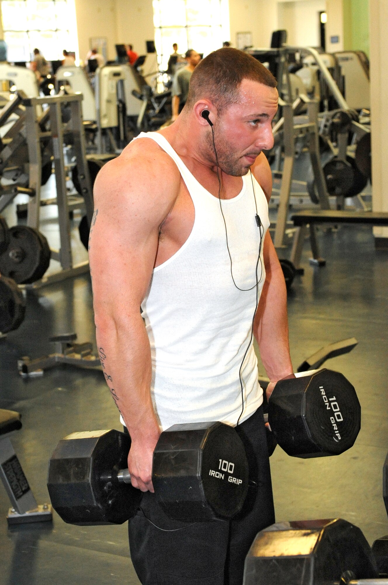 With music in his ear, Bobby Beam, a contractor with the 305th Medical Group, works out his upper body with shoulder shrugs during his lunch hour at the McGuire Fitness Center. The fitness center offers everything that major fitness centers offer - including sauna and steam rooms, free weights, nautilus equipment, aerobic equipment and more - but without the annual fees. (U.S. Air Force photo/Wayne Russell)

