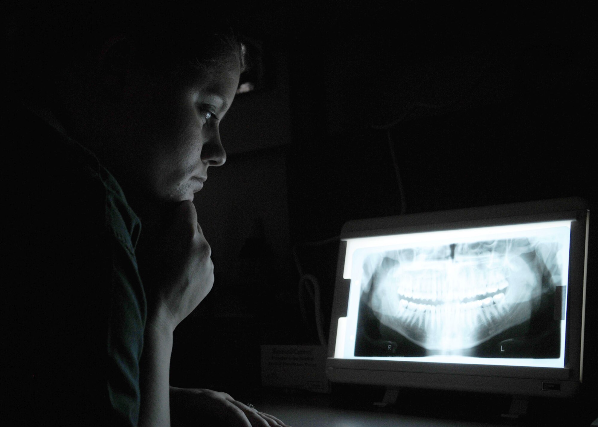 Senior Airman Kari Blankenship, a dental technician from the 48th Dental Squadron, reviews an x-ray during an initial examination Jan. 15, 2009, at RAF Mildenhall, England. X-rays provide dentists and technicians detailed imagery inside the mouth, teeth, and gums to ensure accuracy during examinations. (U.S. Air Force photo by Staff Sgt. Jerry Fleshman)