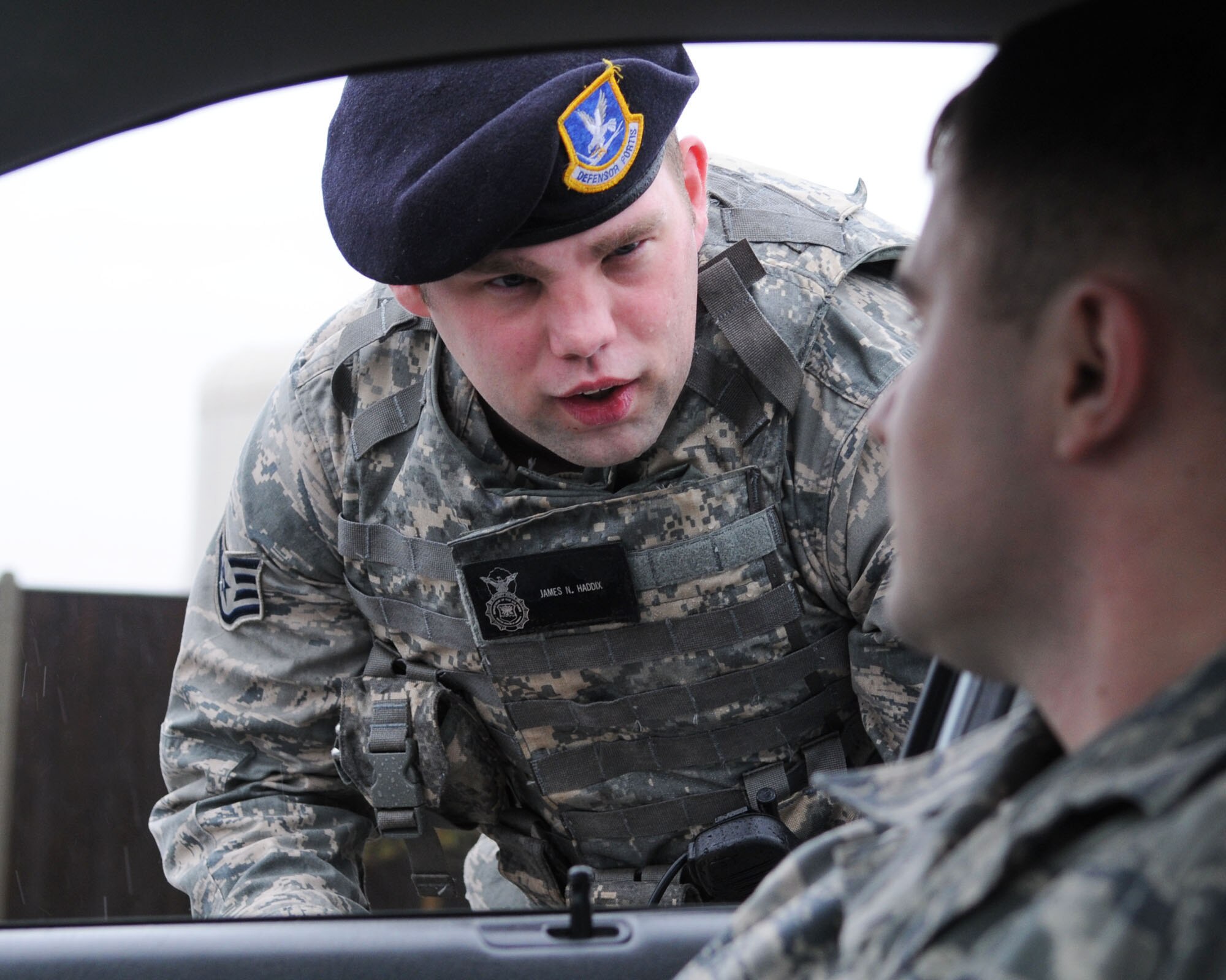 Staff Sgt. James Haddix, from the 100th Security Forces Squadron, explains the importance of following all posted speed limits to Airman 1st Class Daniel Hayes during a training exercise Jan. 22, 2009, at RAF Mildenhall, England.  Security forces Airmen enforce civilian and military laws on base. (U.S. Air Force photo by Staff Sgt. Jerry Fleshman)